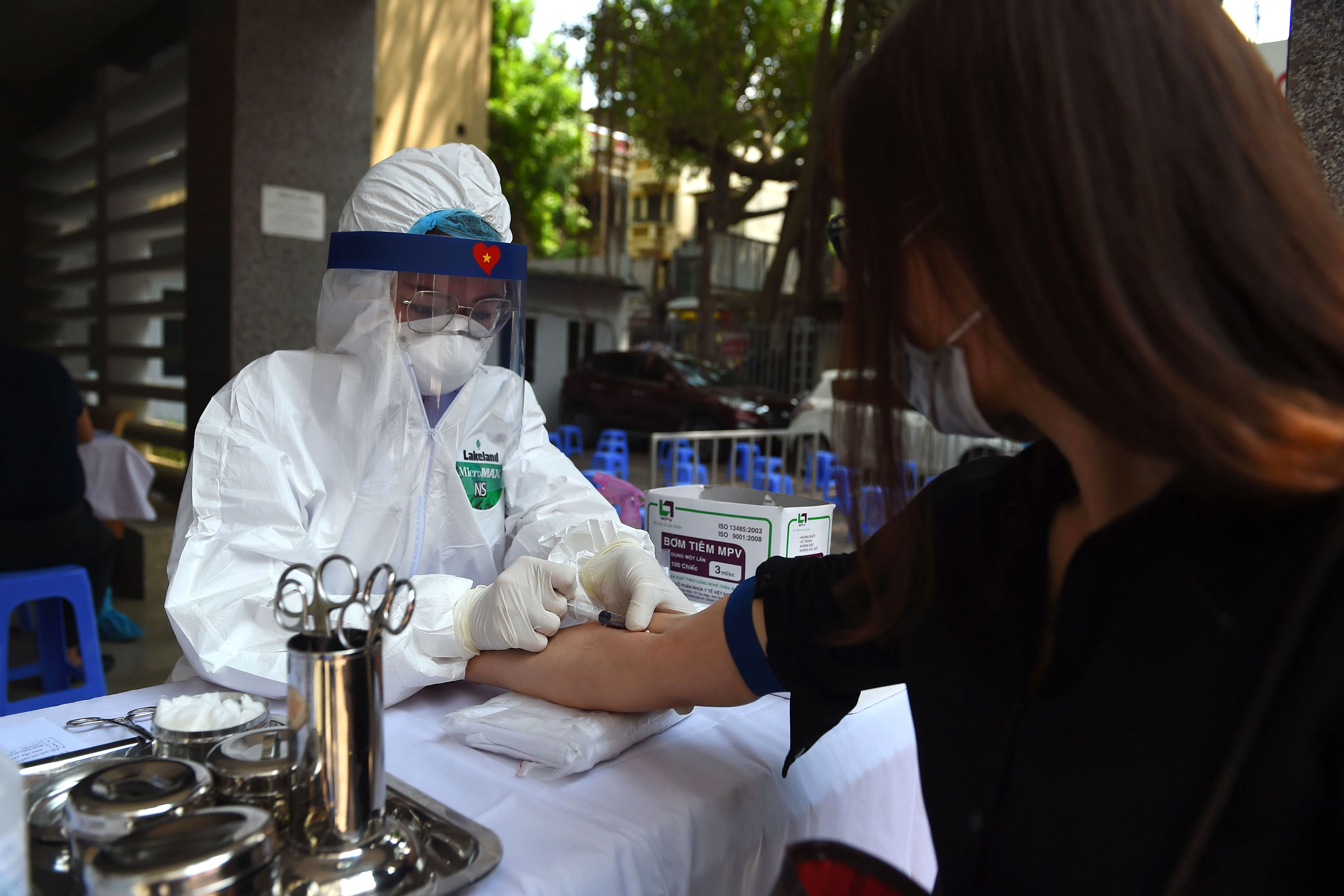 A health worker takes a blood sample from a resident at a coronavirus rapid testing center on July 30 in Hanoi, Vietnam.