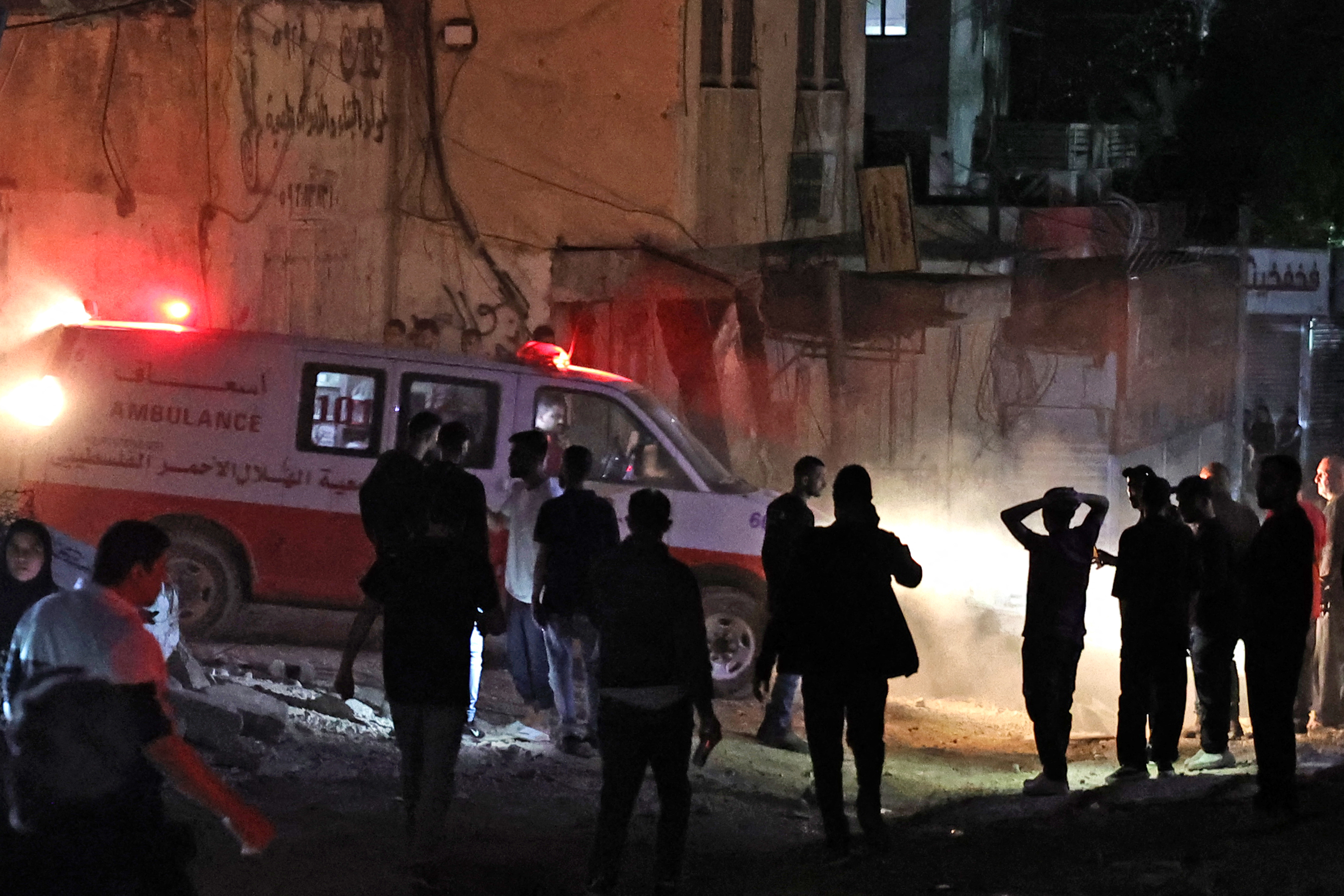 Palestinians gather next to an ambulance following an Israeli raid on a refugee camp in West Bank, on April 20.