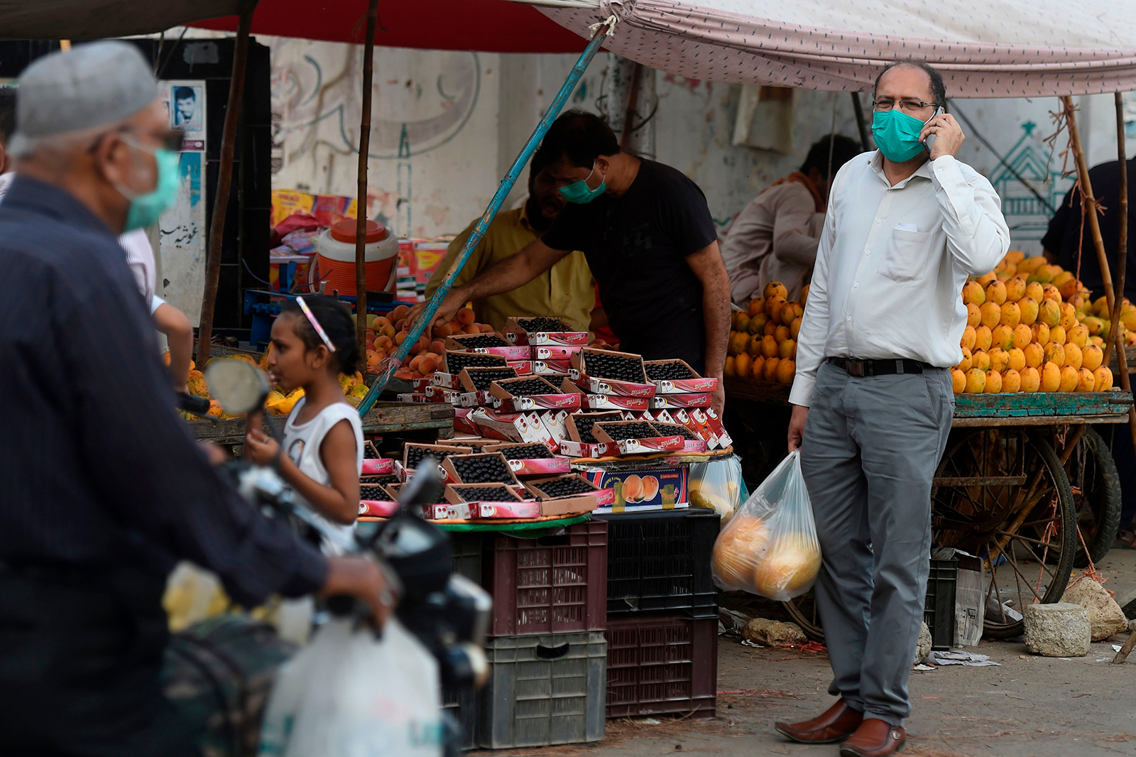 People wearing facemasks buy fruit in Karachi, Pakistan, on June 2.