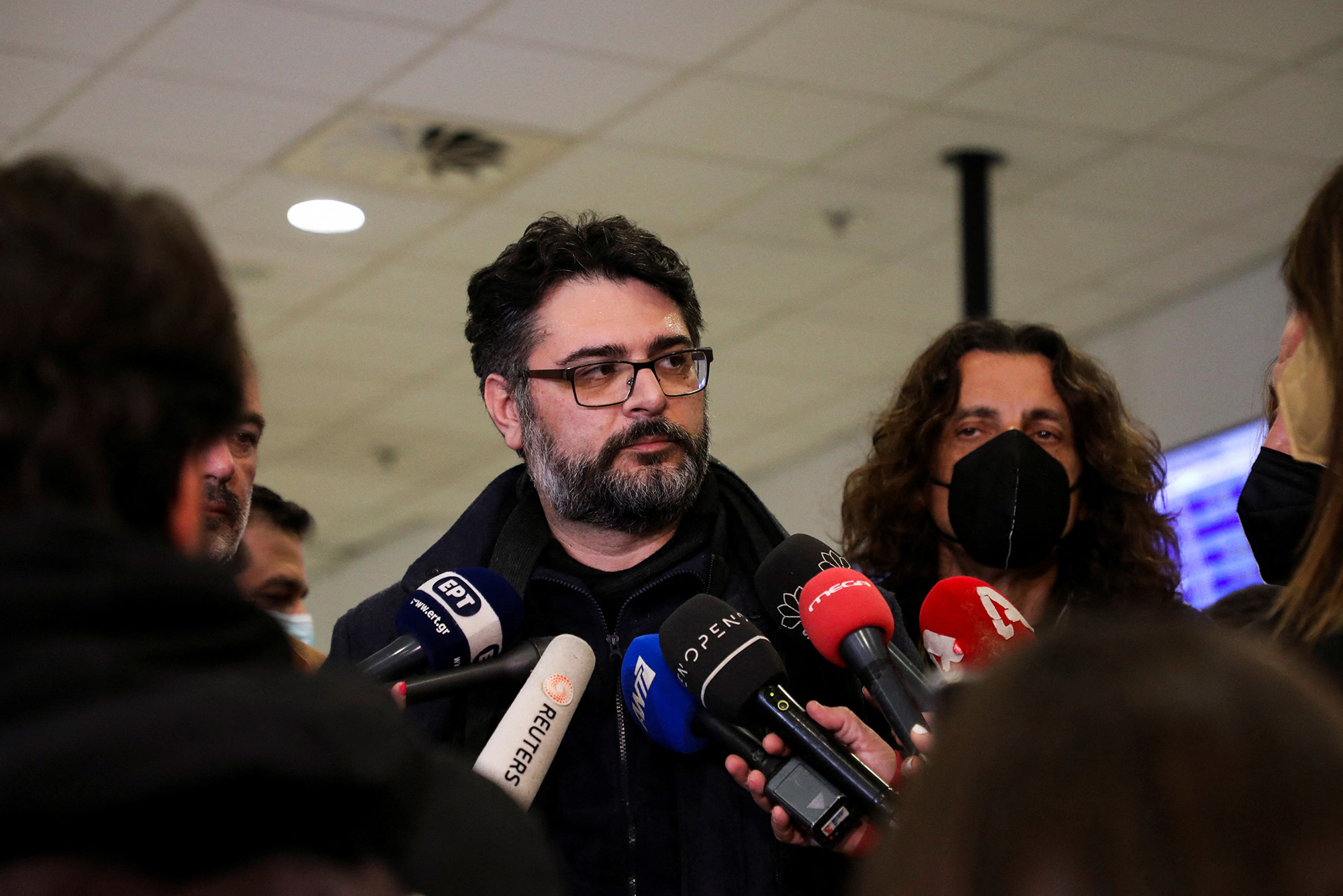 Greece's Consul General Manolis Androulakis, center, talks to the media after arriving back in Athens, Greece, on March 20 after evacuating the city of Mariupol, Ukraine.