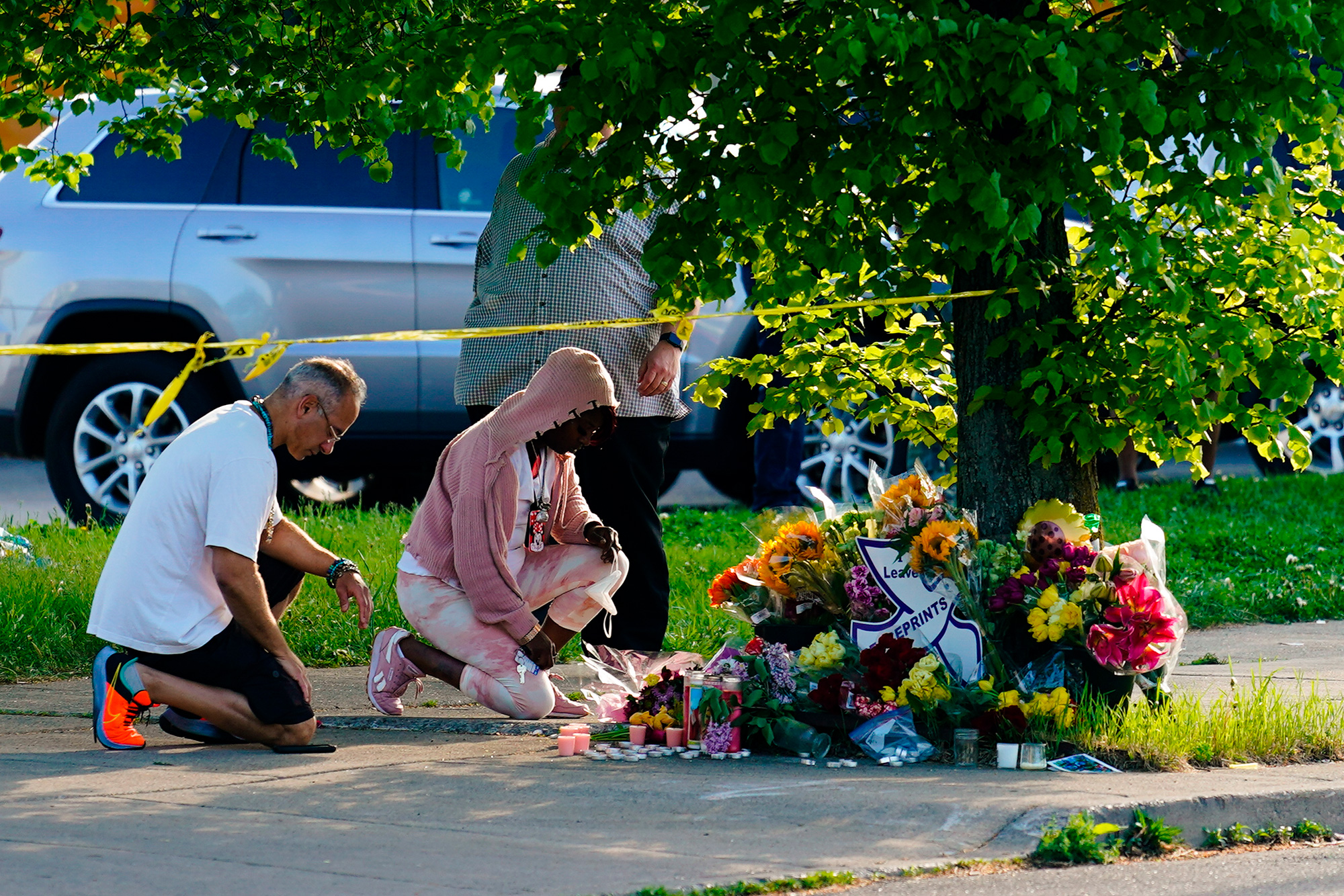 People pay their respects outside the scene of a shooting at a supermarket in Buffalo, New York, Sunday, May 15.