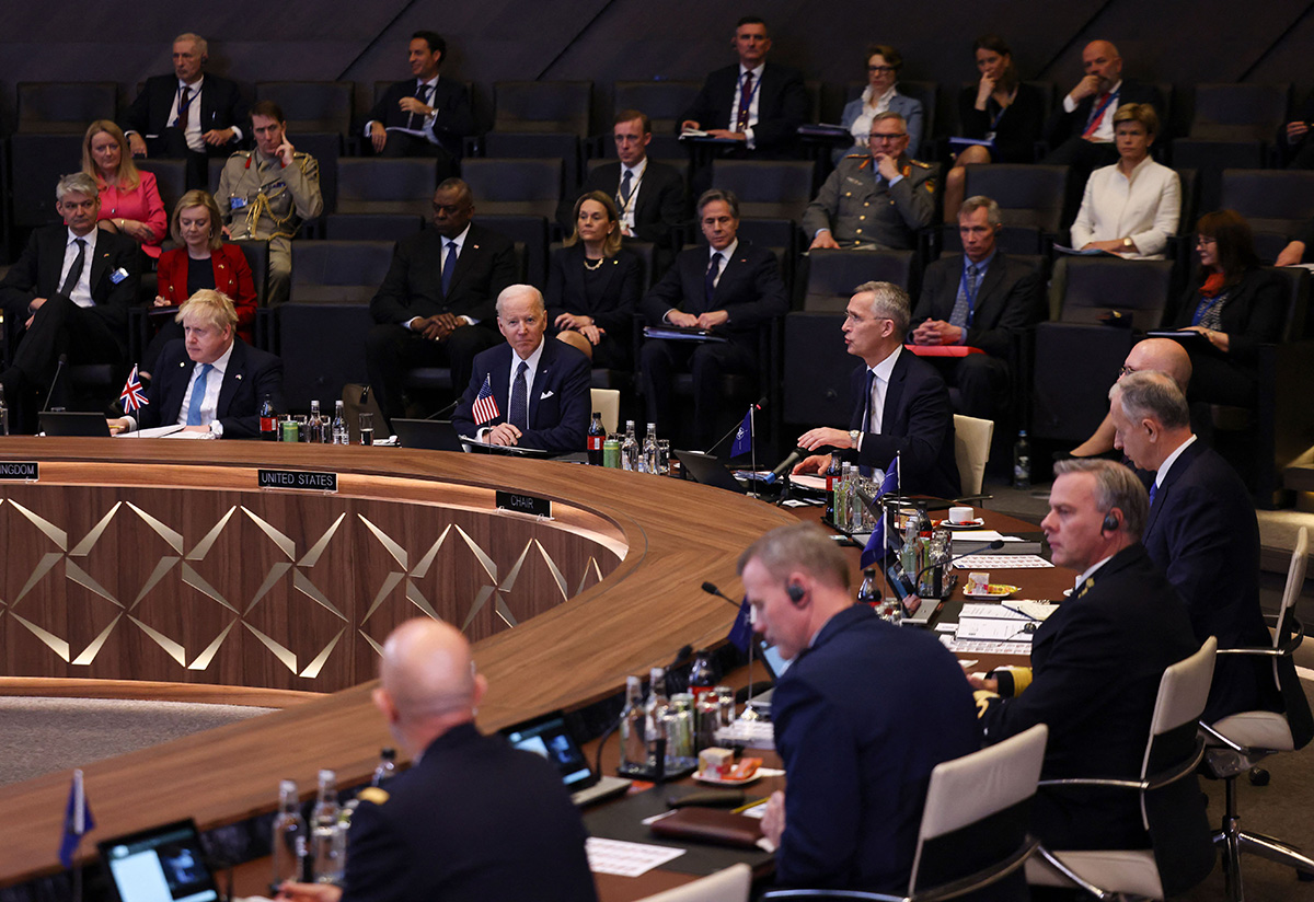 British Prime Minister Boris Johnson, left, and U.S. President Joe Biden, center, listen as NATO Secretary General Jens Stoltenberg addresses a North Atlantic Council meeting during an extraordinary summit at NATO Headquarters in Brussels, Belgium, on March 24.
