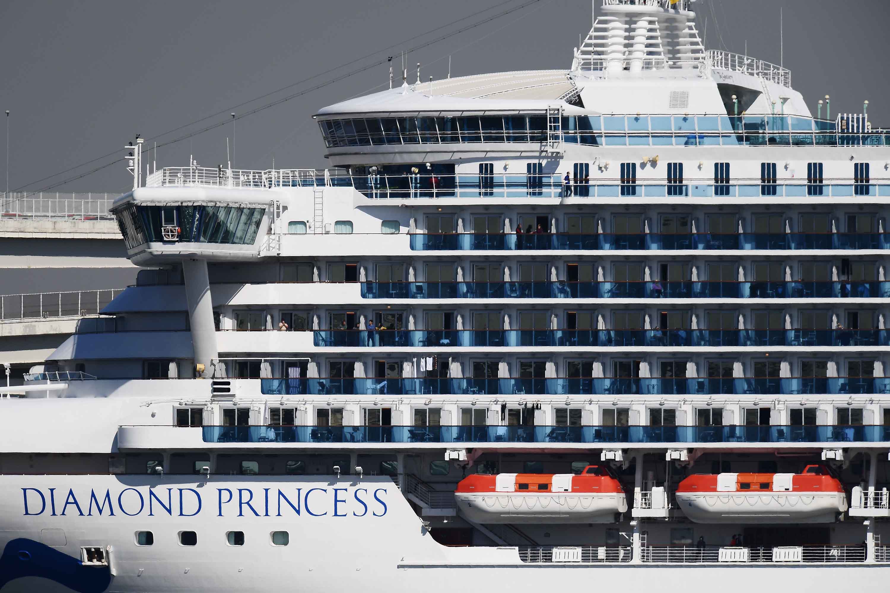 Passengers stand on balconies on the Diamond Princess cruise ship at the Daikoku Pier Cruise Terminal in Yokohama, Japan, on Monday.