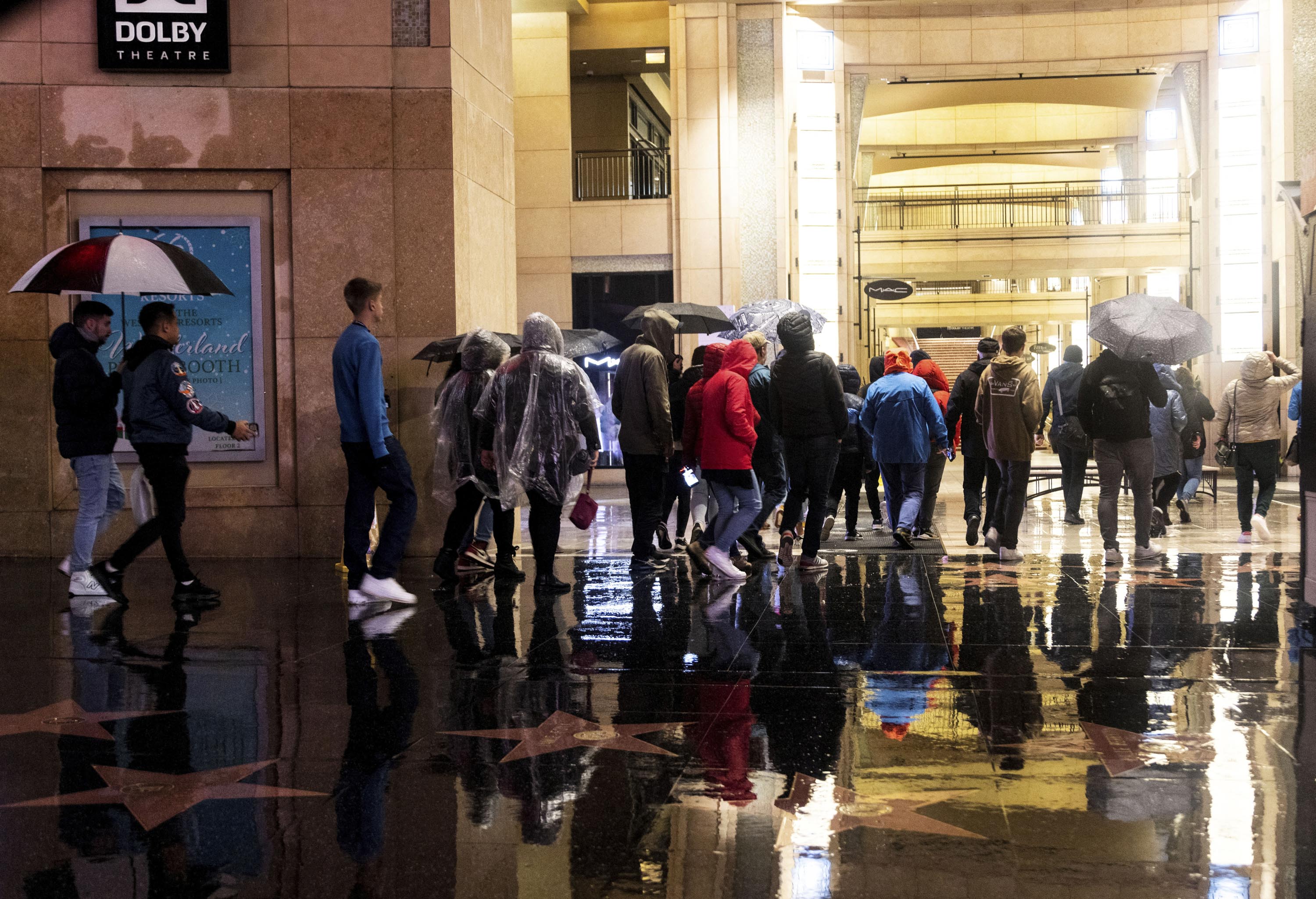 A group of tourists walk on Hollywood Boulevard during an ongoing rain storm in Los Angeles, California, on February 5. 