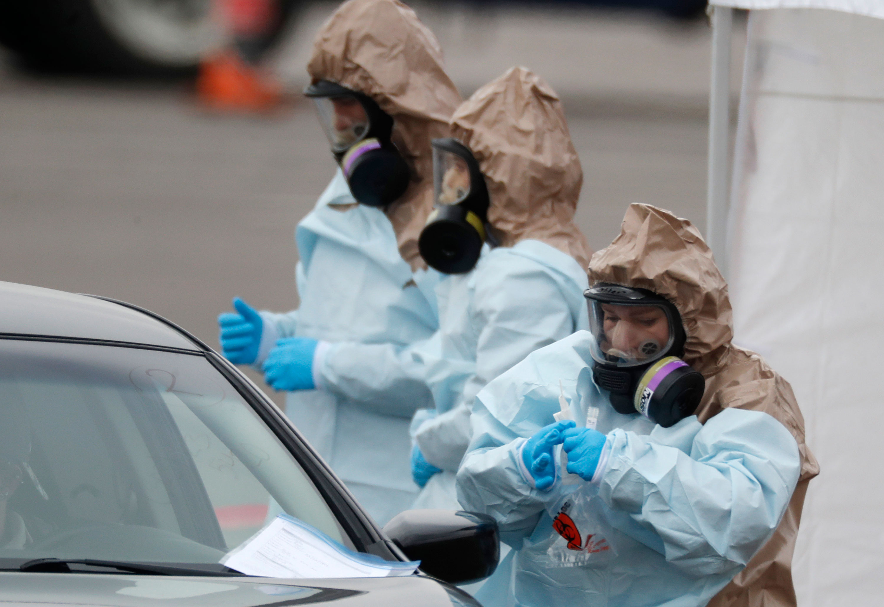 Colorado National Guard medical personnel perform coronavirus tests at a drive-through testing site in Denver on March 14. 