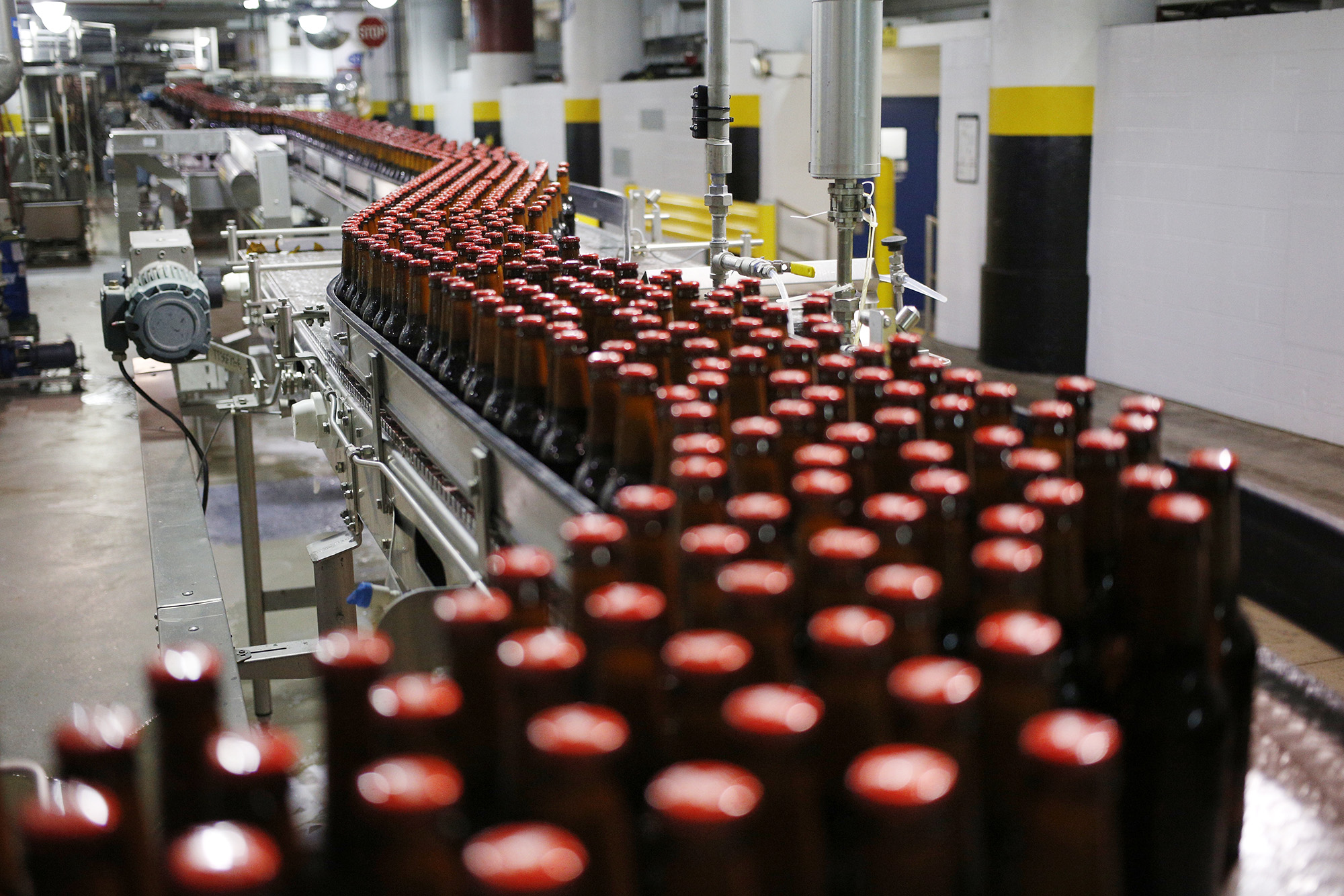 Bottles of beer move along a conveyor belt at the Anheuser-Busch InBev NV Budweiser bottling facility in St. Louis, Missouri, U.S., on October 24, 2017.