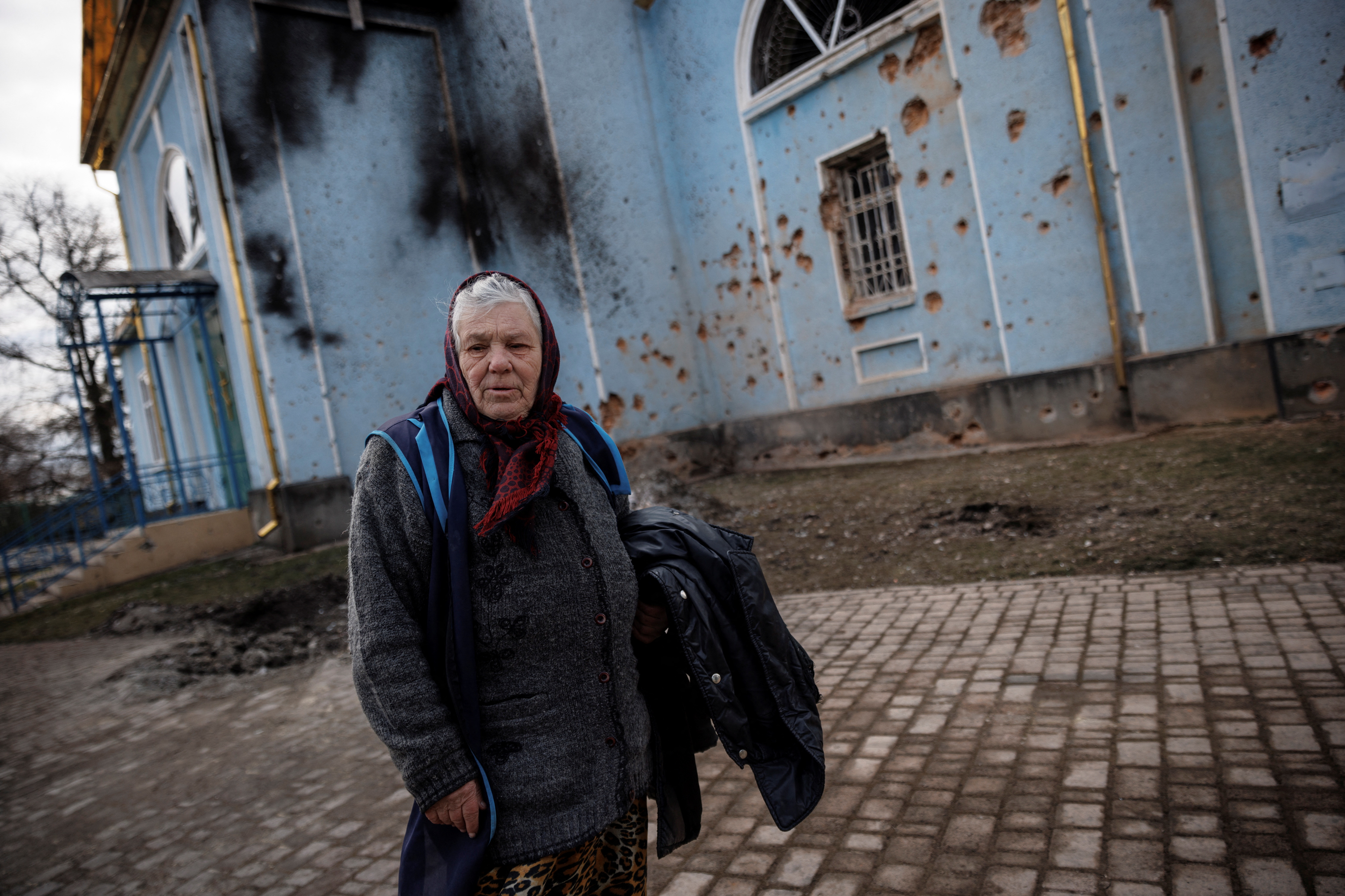 A woman walks past a church that was damaged during heavy shelling in the town of Derhachi outside Kharkiv, Ukraine, on April 6.