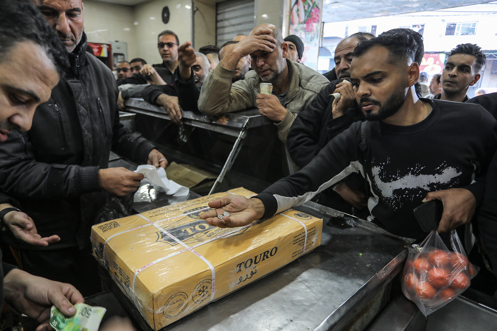 Palestinians buy food at a butcher shop in Rafah, Gaza, on December 30. 