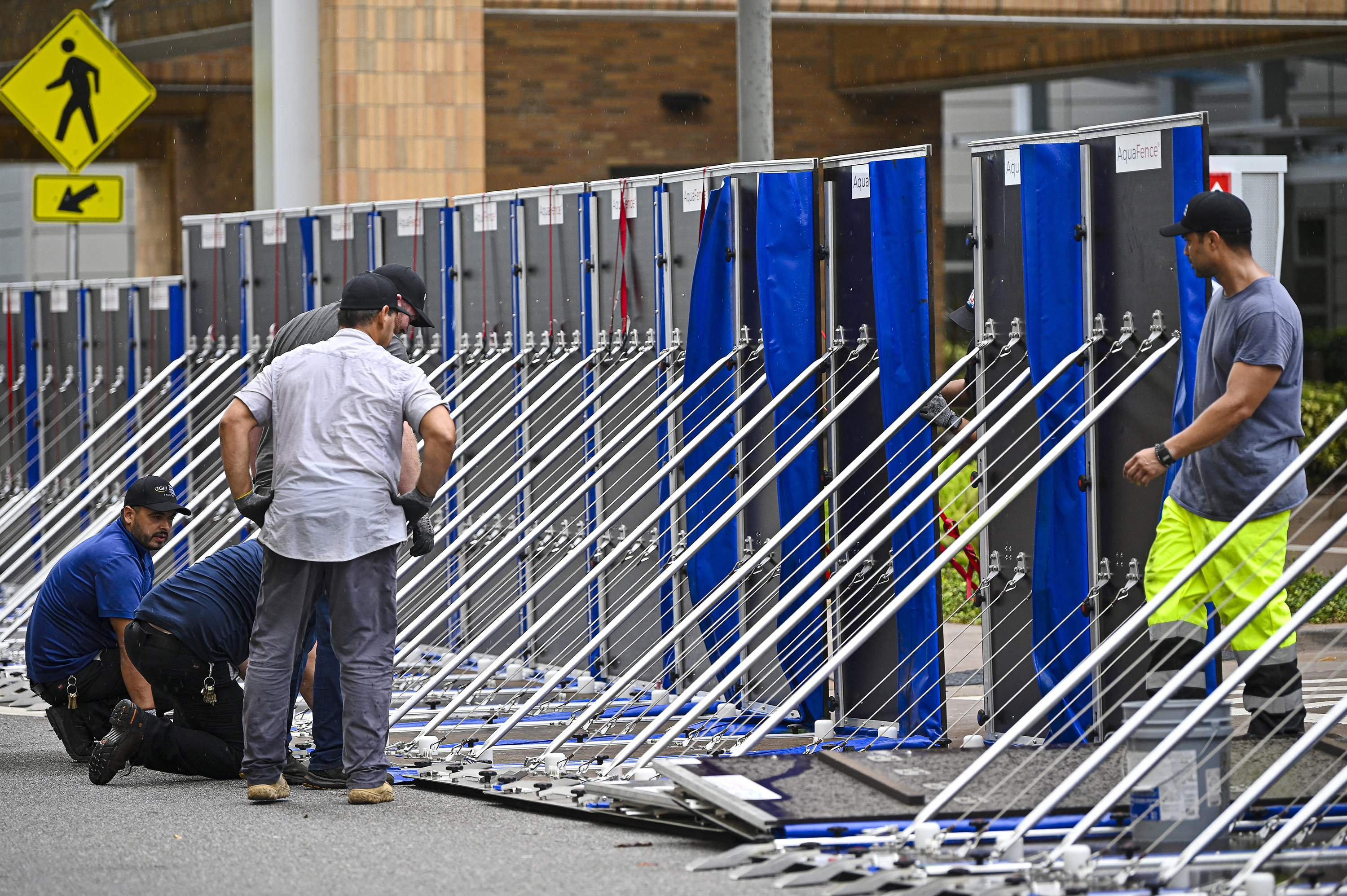 Workers set up a fence to prevent flooding at Tampa General Hospital in Tampa, Florida, on August 29, as the city prepares for Hurricane Idalia.
