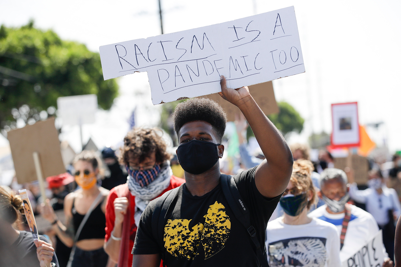 A protester carries a sign during a march in honor of Andres Guardado, on Sunday, June 21, in Compton, California. 