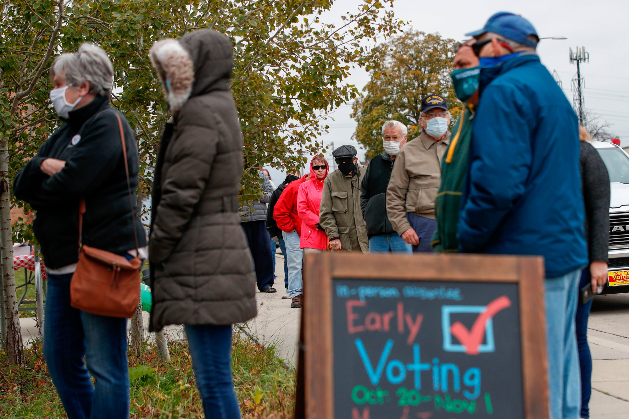 People wait in line to cast their ballots outside Tippecanoe Library in Milwaukee, Wisconsin, on October 20.