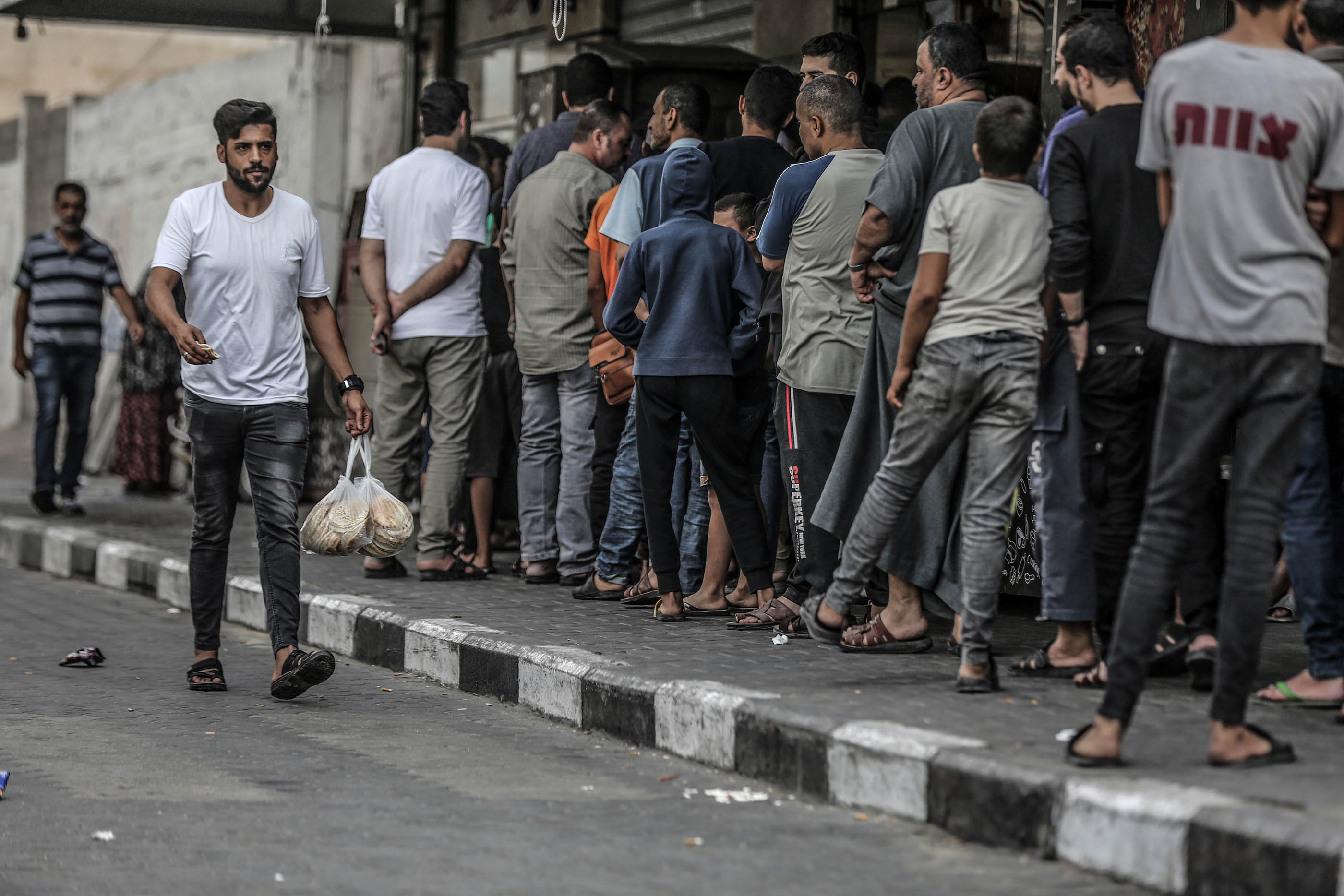 People wait in line at a shop in Gaza City on October 17. 