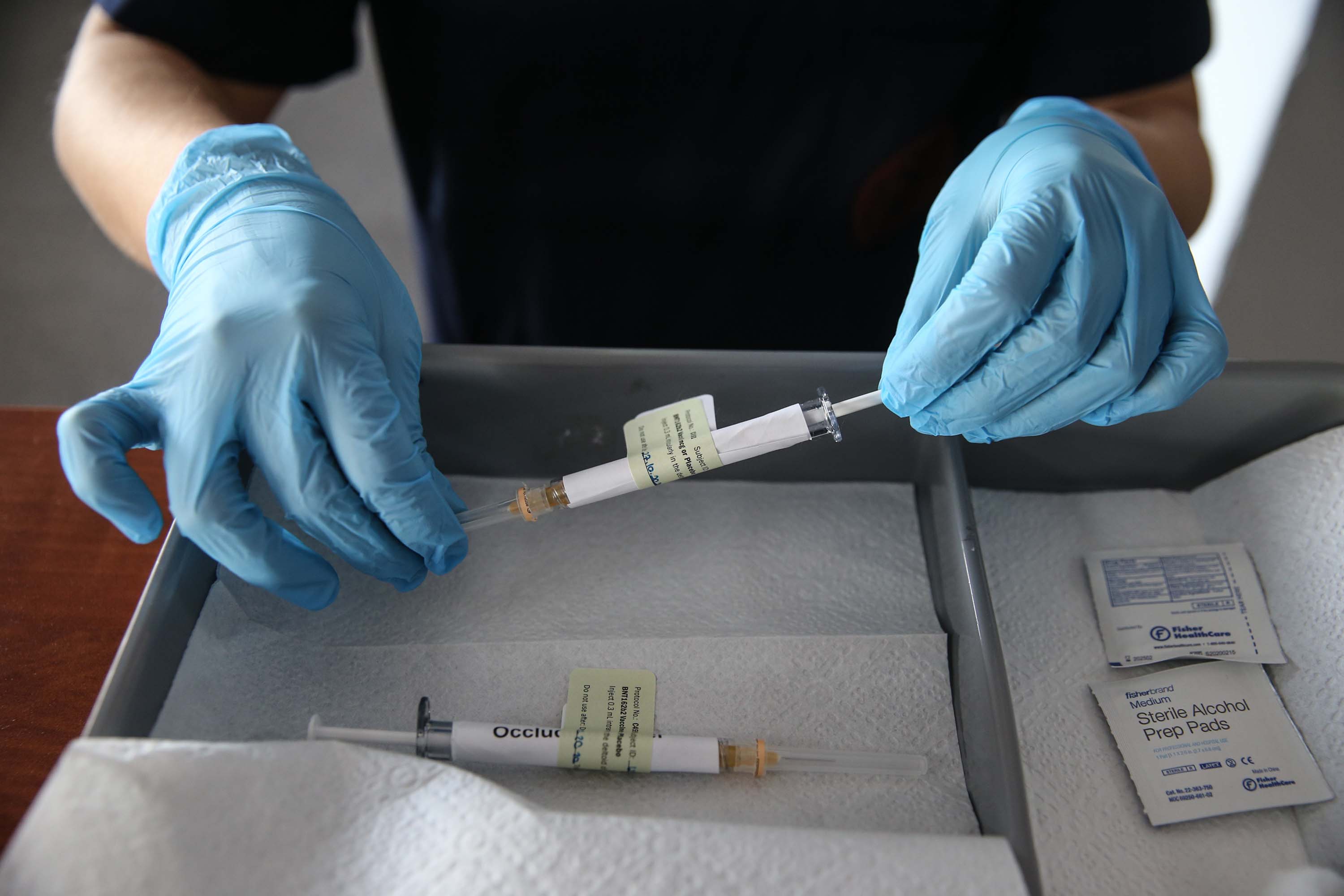 A health care worker holds an injection syringe of the phase 3 vaccine trial, developed against the novel coronavirus pandemic by the American drugmaker, Pfizer, and German company BioNTech, at the Ankara University Ibni Sina Hospital in Ankara, Turkey on October 27.