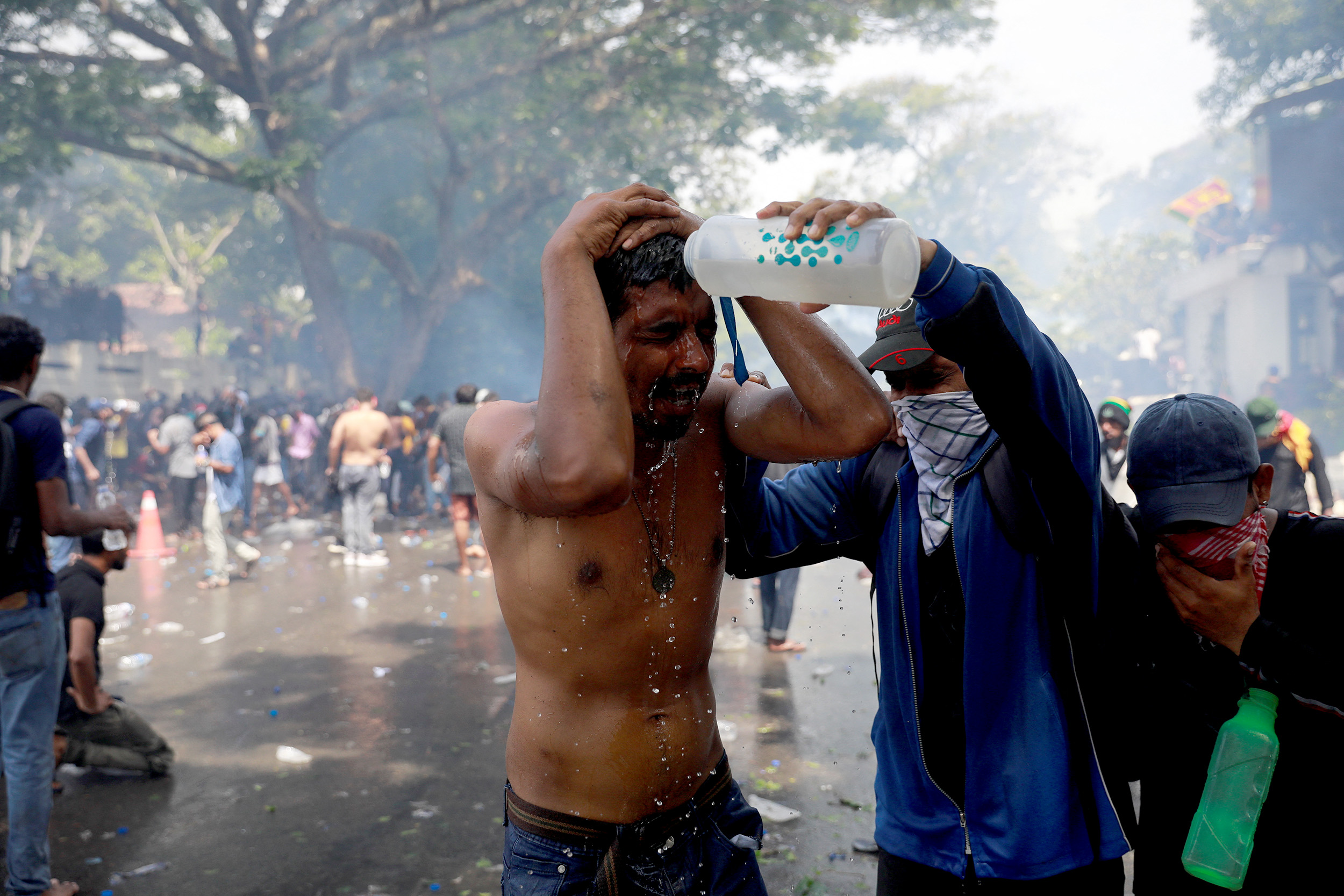 A demonstrator pours water on a man during a protest outside the office of Sri Lanka's Prime Minister Ranil Wickremesinghe in Colombo, Sri Lanka, on July 13.