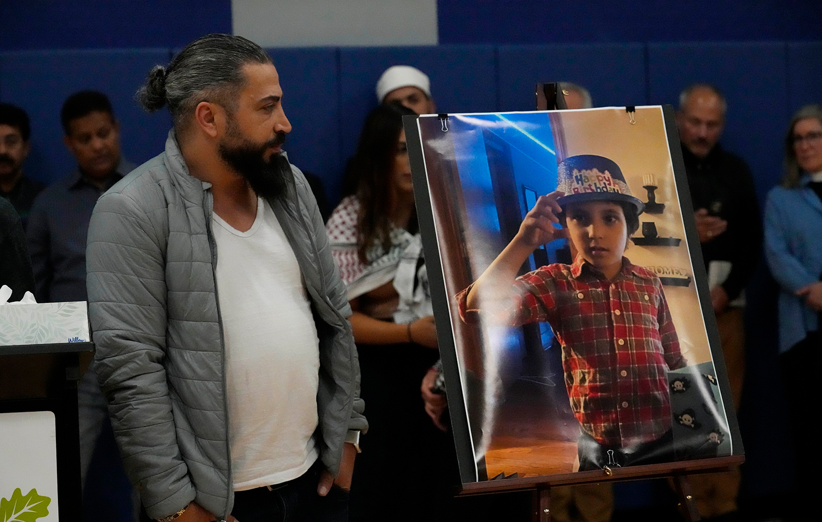 Oday Al-Fayoume looks at a photo of his son Wadea Al-Fayoume during a vigil at Prairie Activity and Recreation center in Plainfield, on October 17.