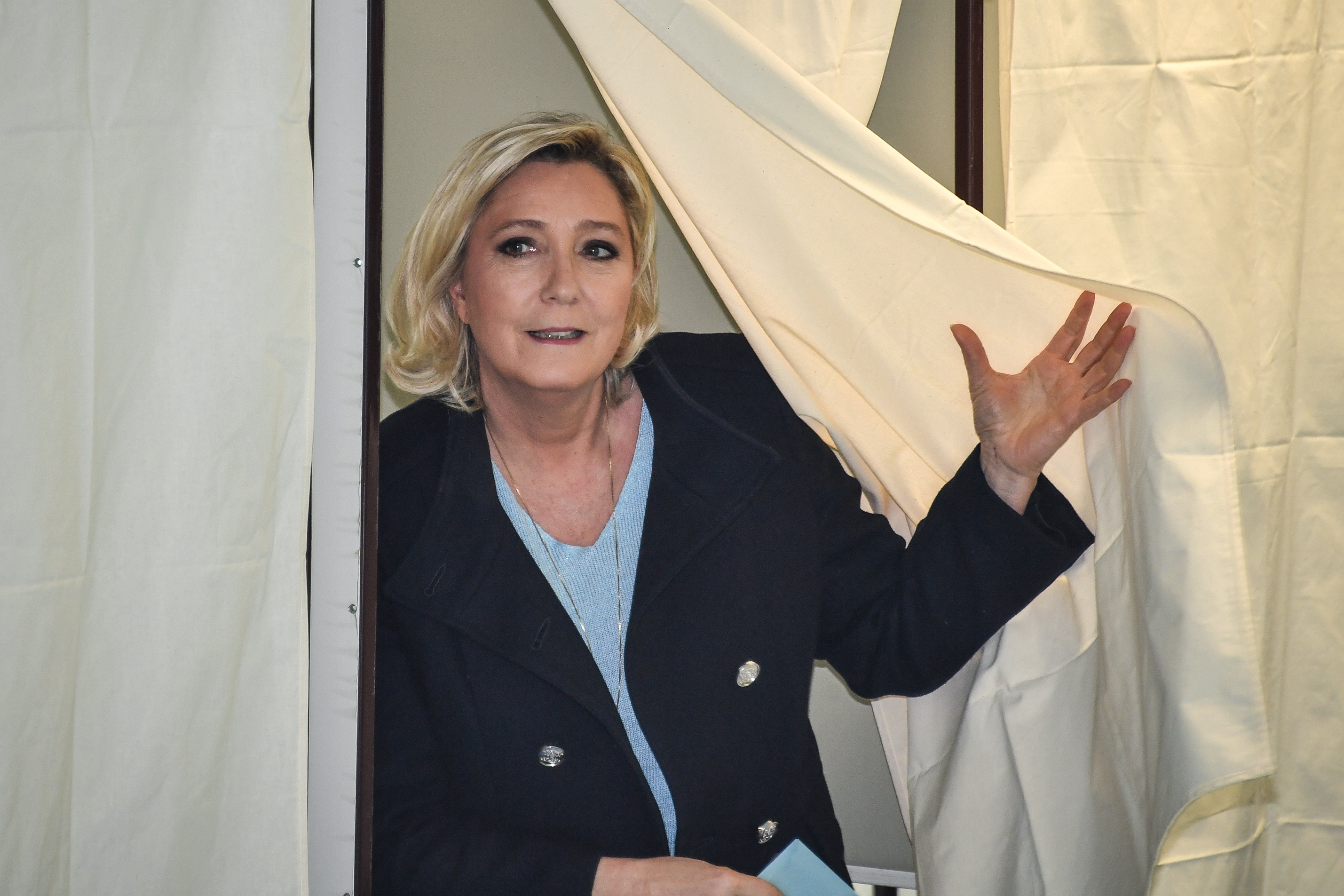 French far-right National Rally president Le Pen leaves the polling booth to cast her vote for the European Parliament.