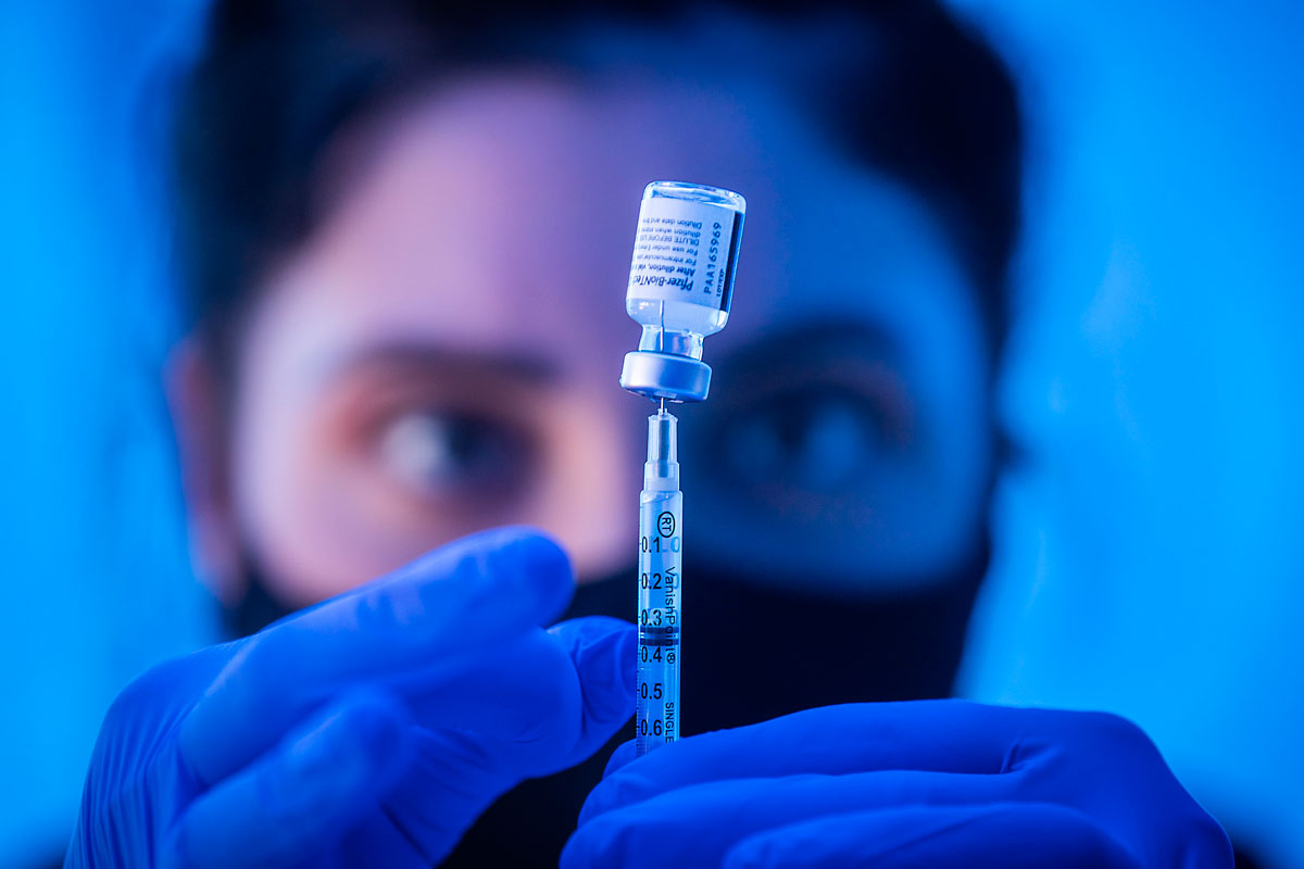 A medical student from Dartmouth University loads a syringe with the Pfizer Covid-19 vaccine on the first day of eligibility for people ages 16 and up, at Kedren Health on April 15 in Los Angeles, CA.