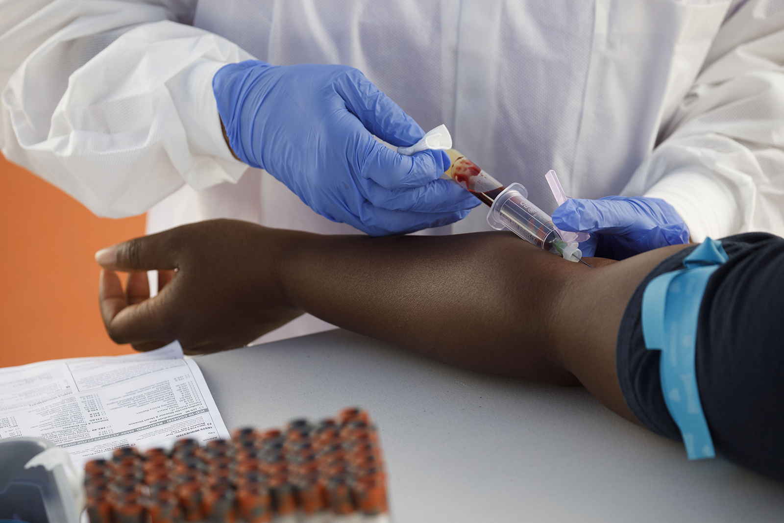 A phlebotomist wearing protective gloves draws blood from a patient for a Covid-19 antibody test at a GUARDaHEART Foundation testing site in Los Angeles, California, on August 5.