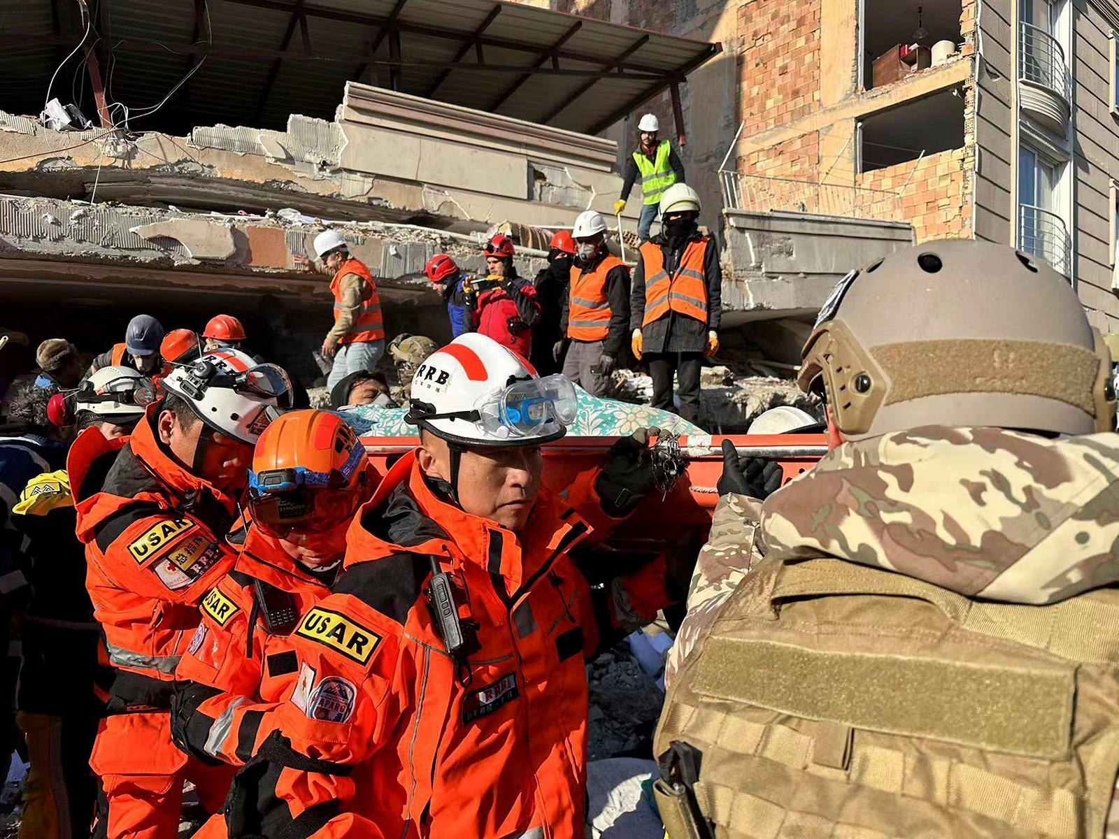 Members of rescue teams work to free survivors from a heavily damaged building in Belen Town of Iskenderun City, in southern Turkey's Hatay province, on February 9.