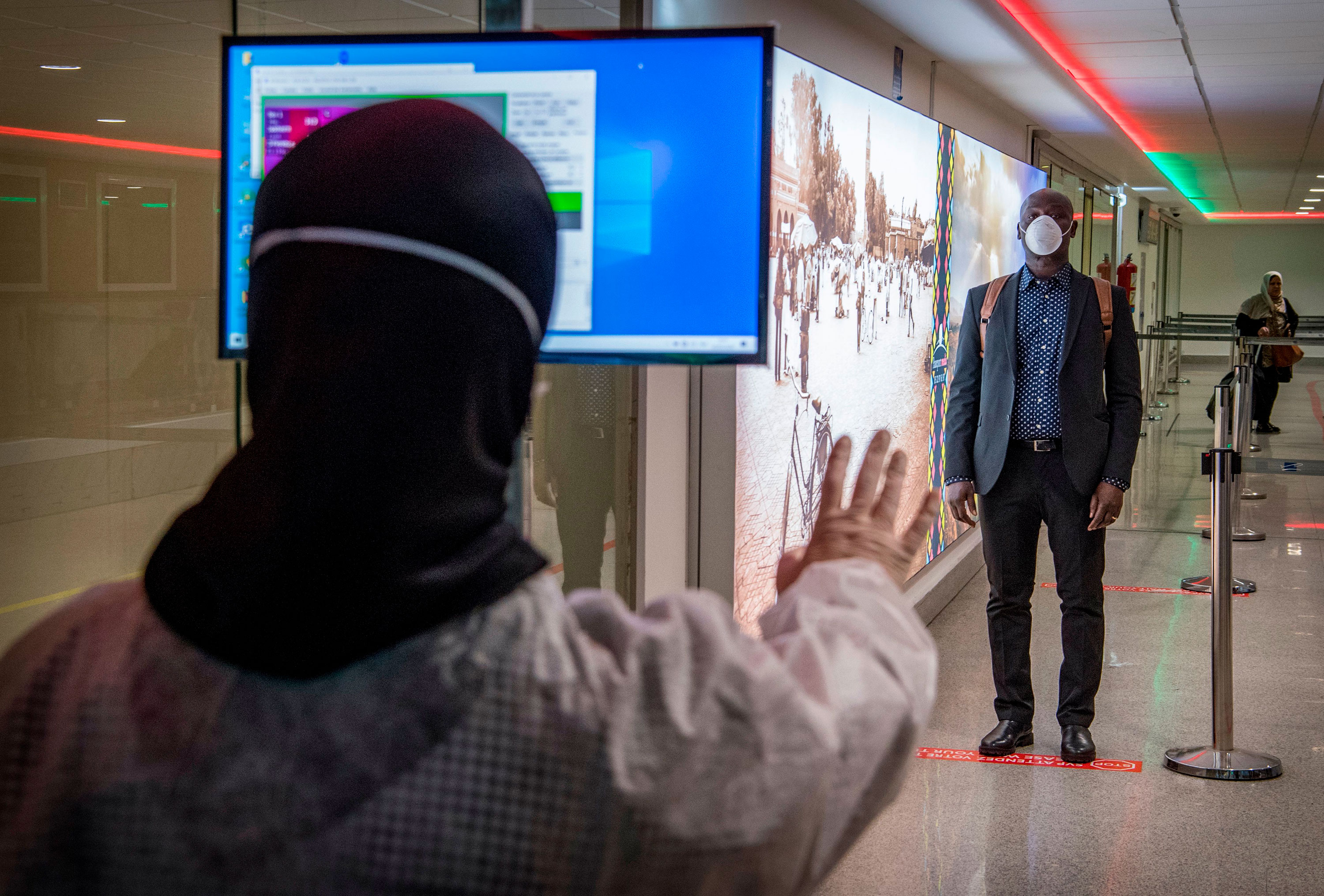 Moroccan health workers scan passengers arriving from Italy at Casablanca Mohammed V International Airport on March 3.