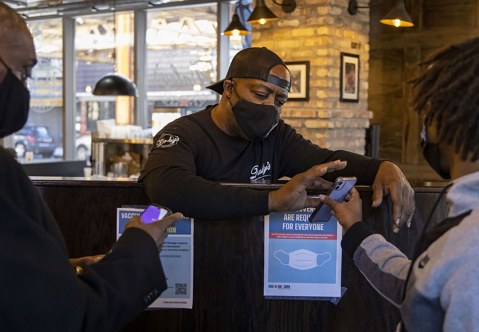 Arthur Mickle checks vaccine cards at Daley's Restaurant in Chicago on January 9.