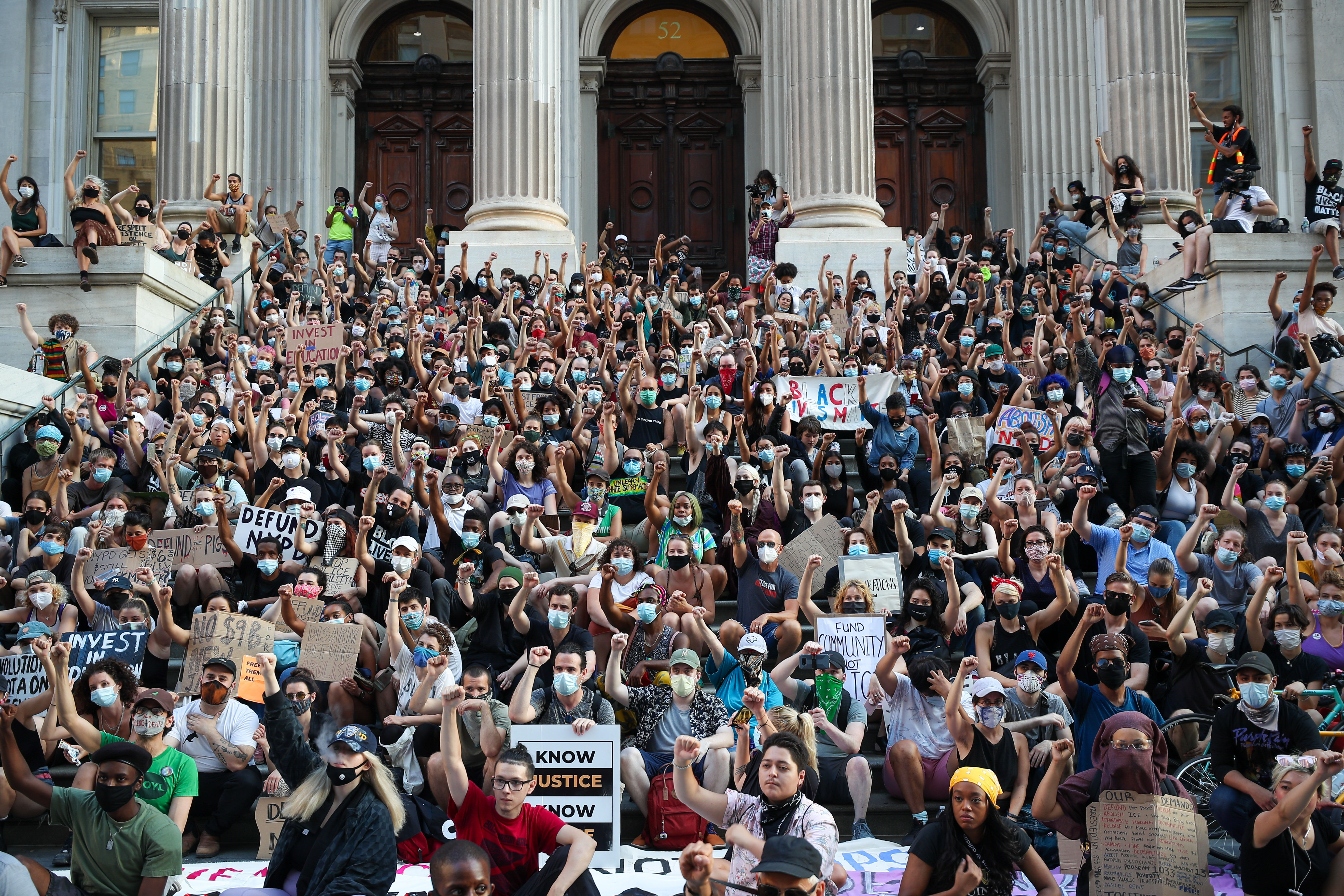 People sit by Tweed Courthouse, near New York City Hall, during an anti-racist protest on June 23.