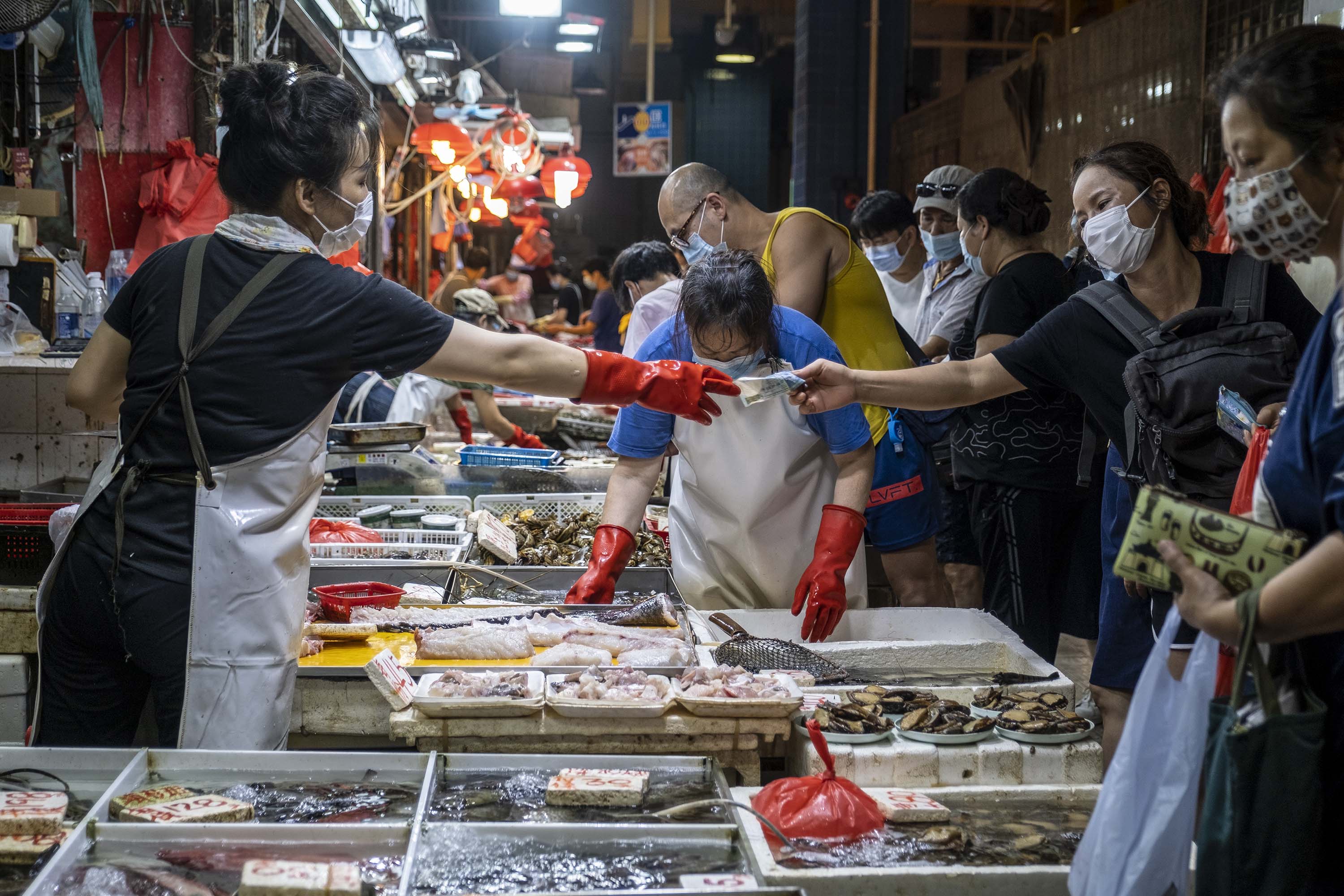 People are seen wearing face masks at a wet market Hong Kong on Saturday, July 25.