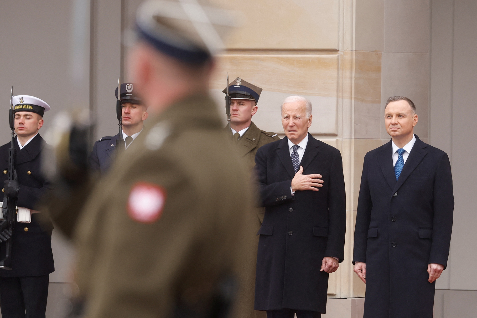 U.S. President Joe Biden and Polish President Andrzej Duda listen to national anthem during a welcome ceremony outside the Presidential Palace in Warsaw, Poland, on February 21.