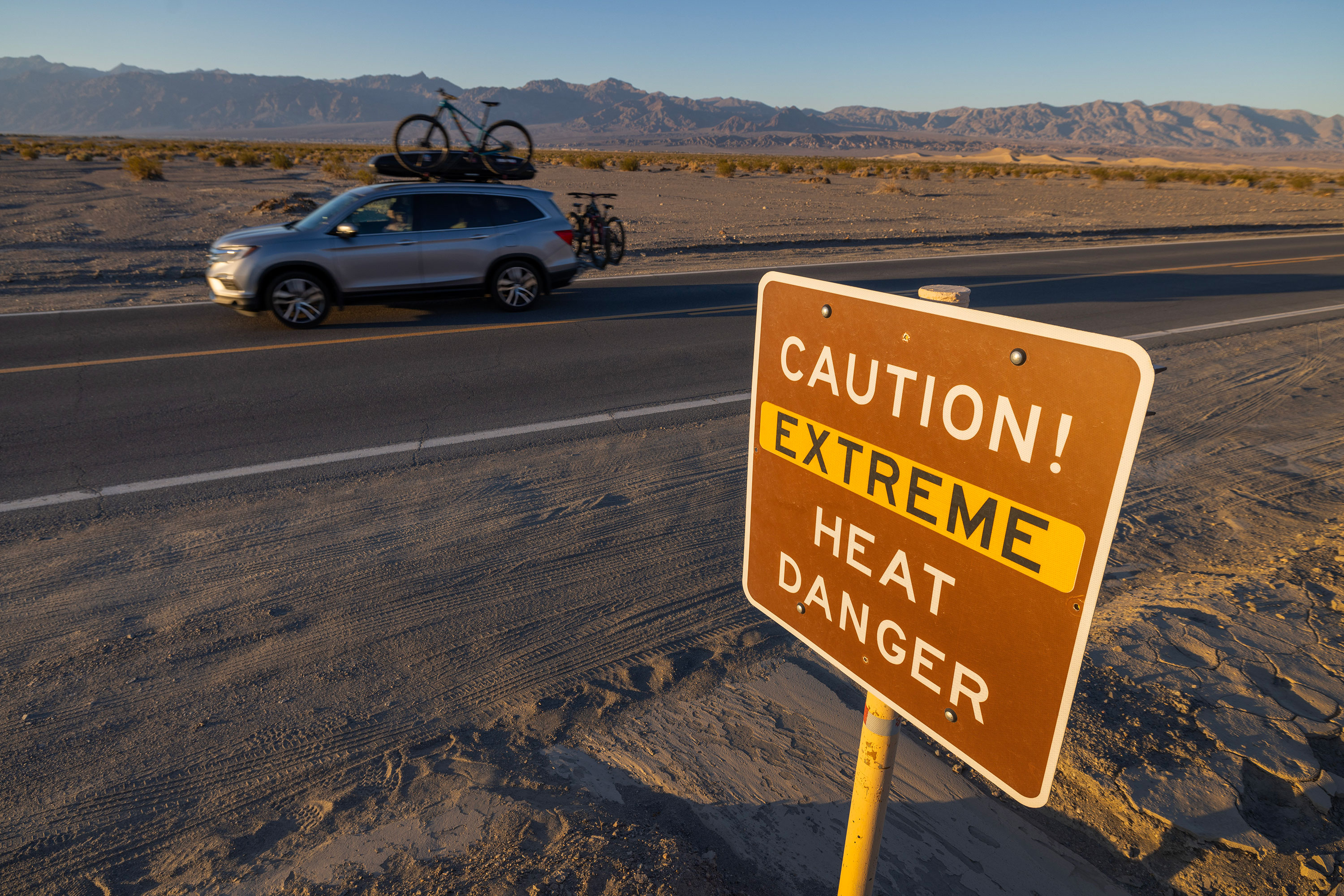 A car passes a sign warning of extreme heat danger in Death Valley National Park on July 15 near Furnace Creek, California. 