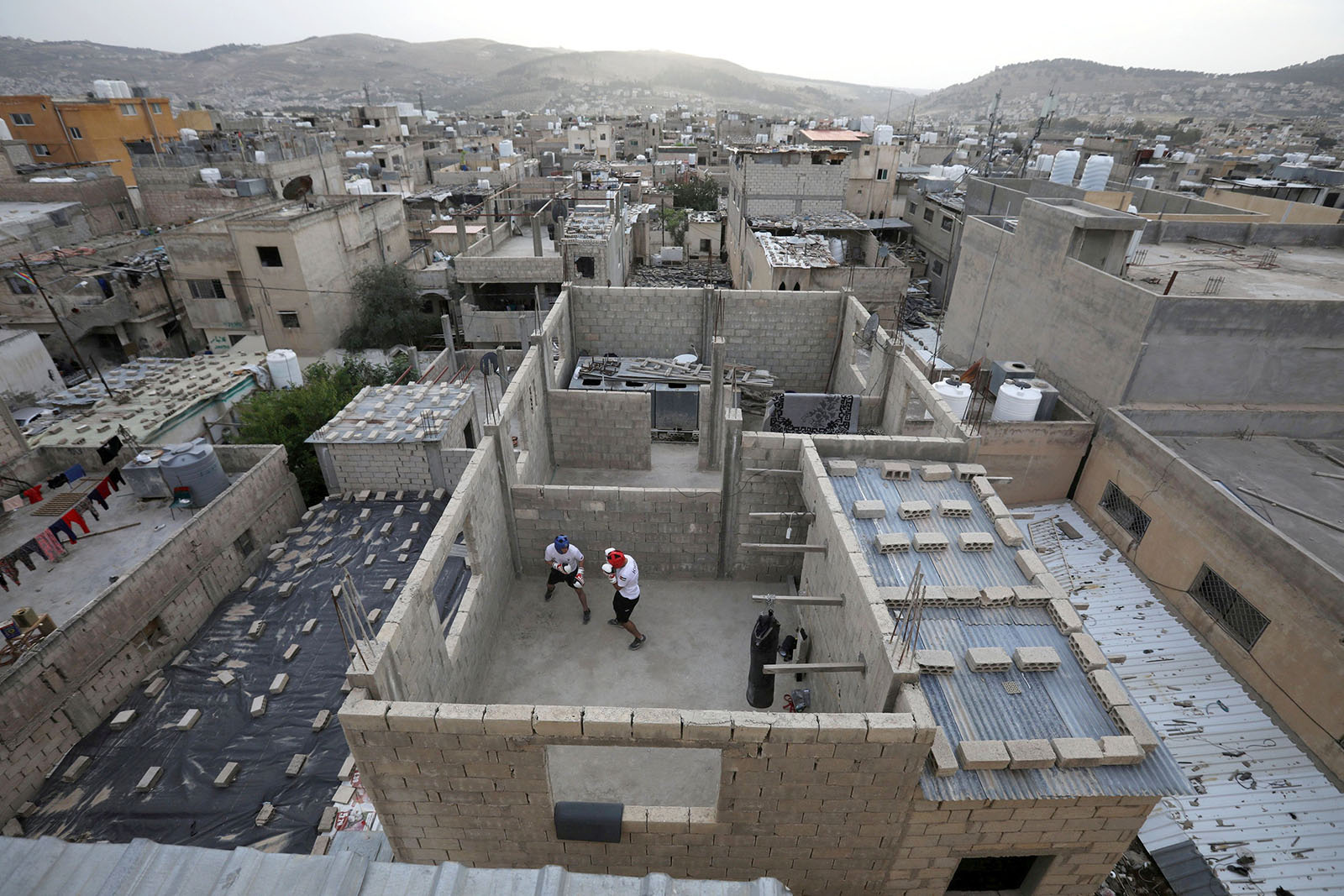 Jordanian boxing brothers Hussein and Zeyad Ashish, who qualified for next year's Olympics, train on the roof of their family home during curfew on May 14 near Amman, Jordan.