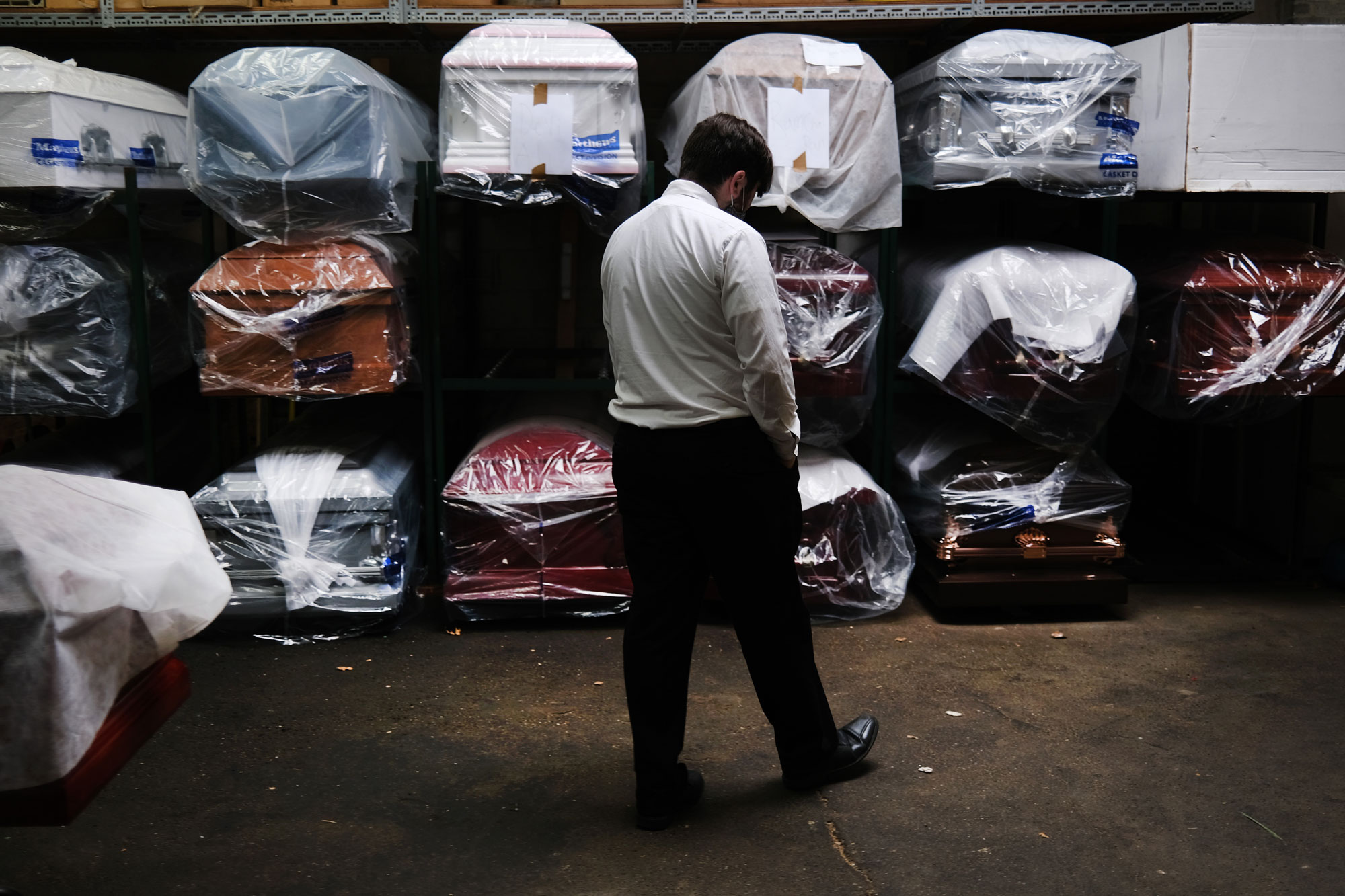 James Harvey tends tends to the inventory of pre-sold caskets at a funeral home on April 29, in New York City. 