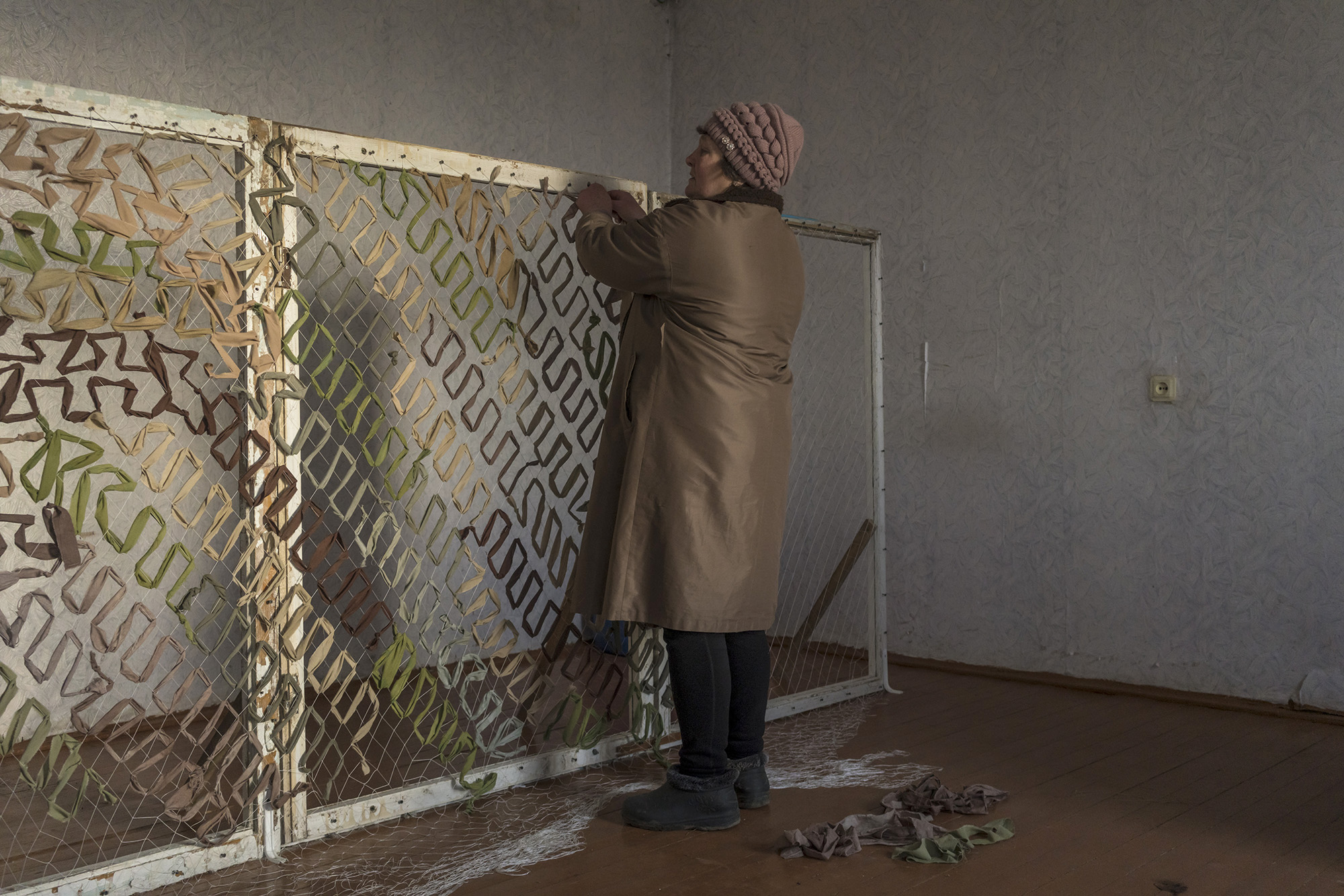 Halyna Kutsenko helps other volunteers to make camouflage nets for the Ukrainian military on February 25, 2023 in Sukhyi Yar, Ukraine. 