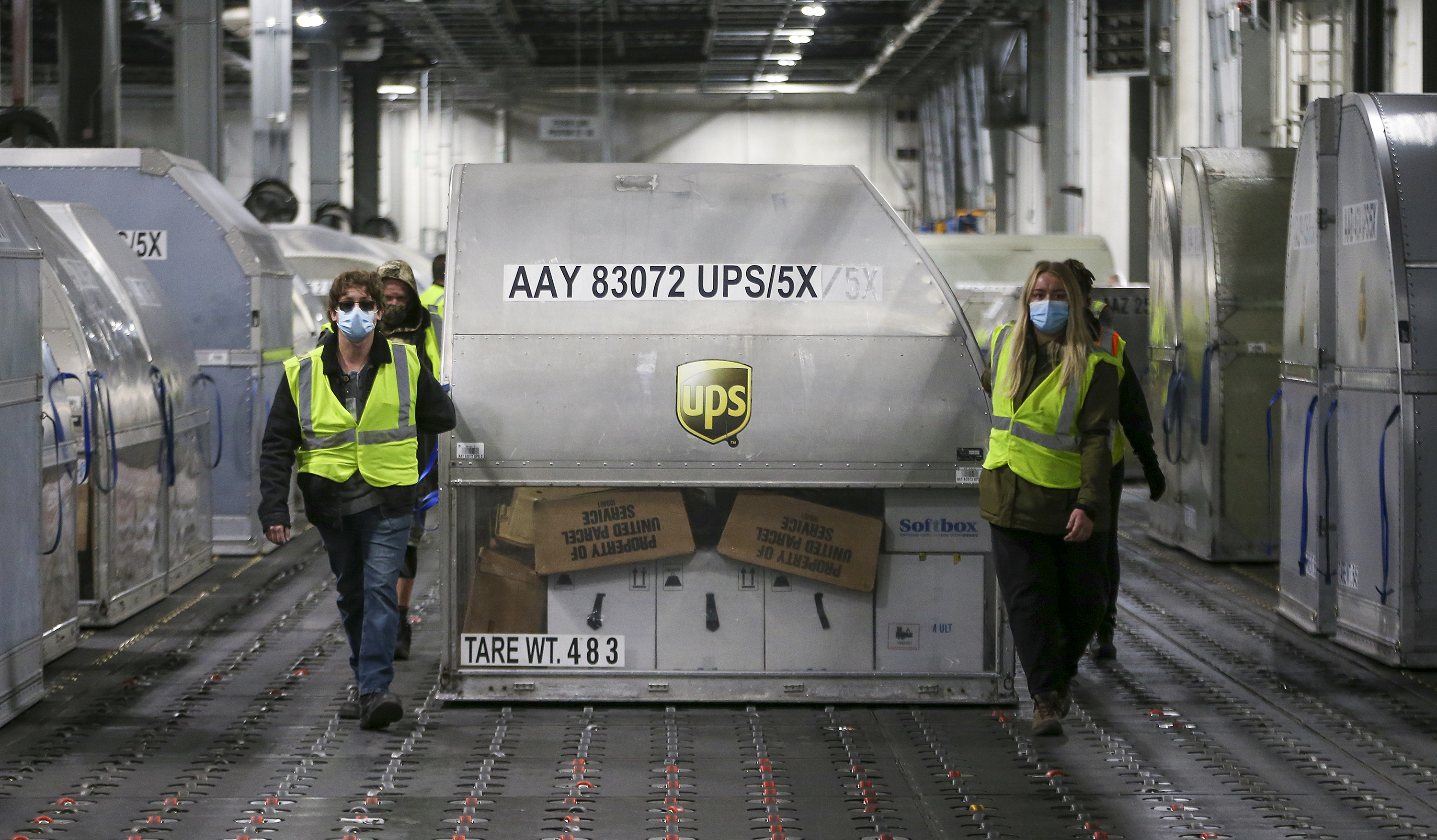 UPS employees move shipping containers containing the Pfizer vaccine inside a sorting facility in Louisville, Kentucky, on December 13.