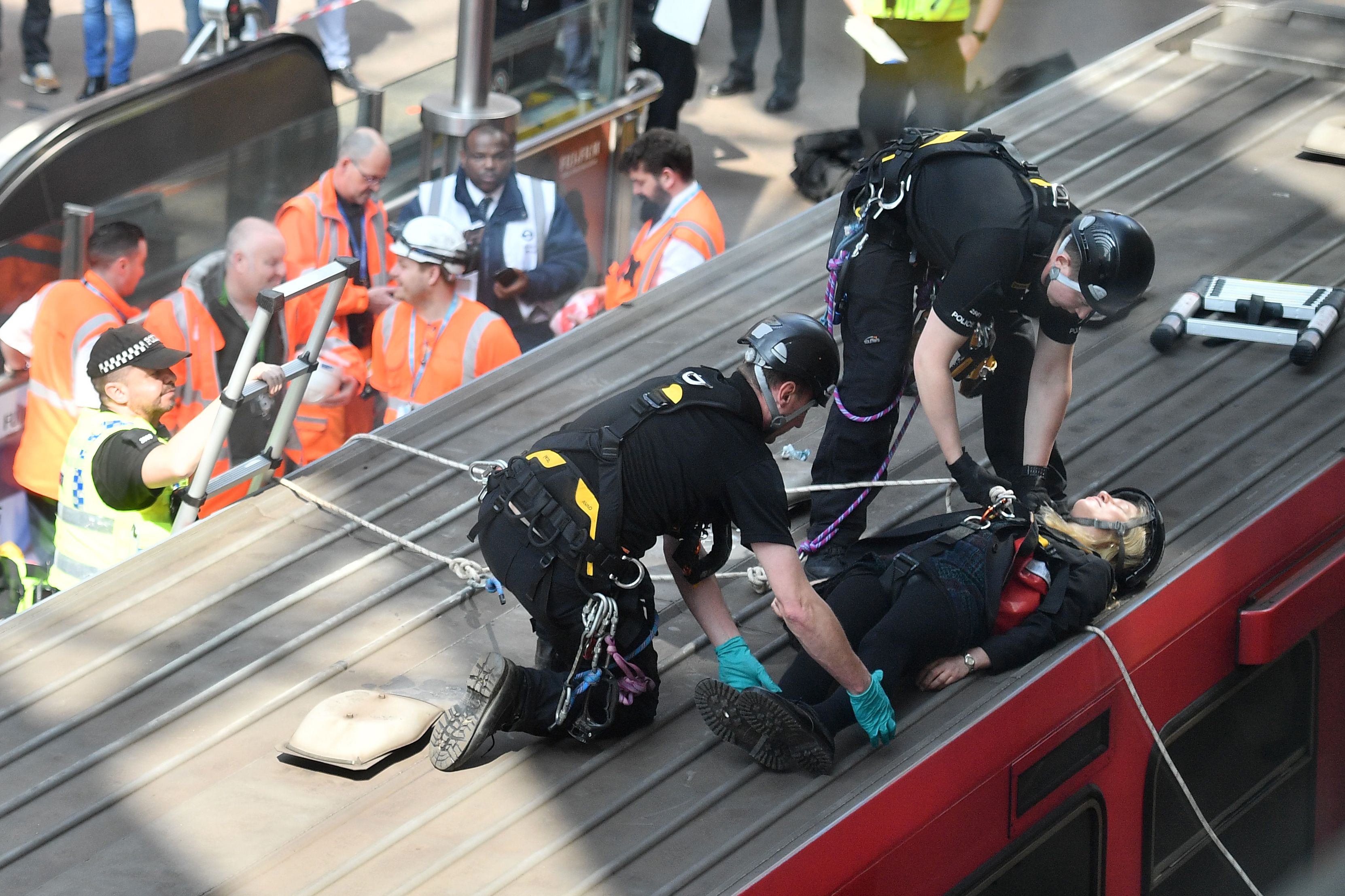 Police remove a climate change protestor from the roof of a train at Canary wharf station on the third day of an environmental protest by the Extinction Rebellion group in London on Wednesday. 