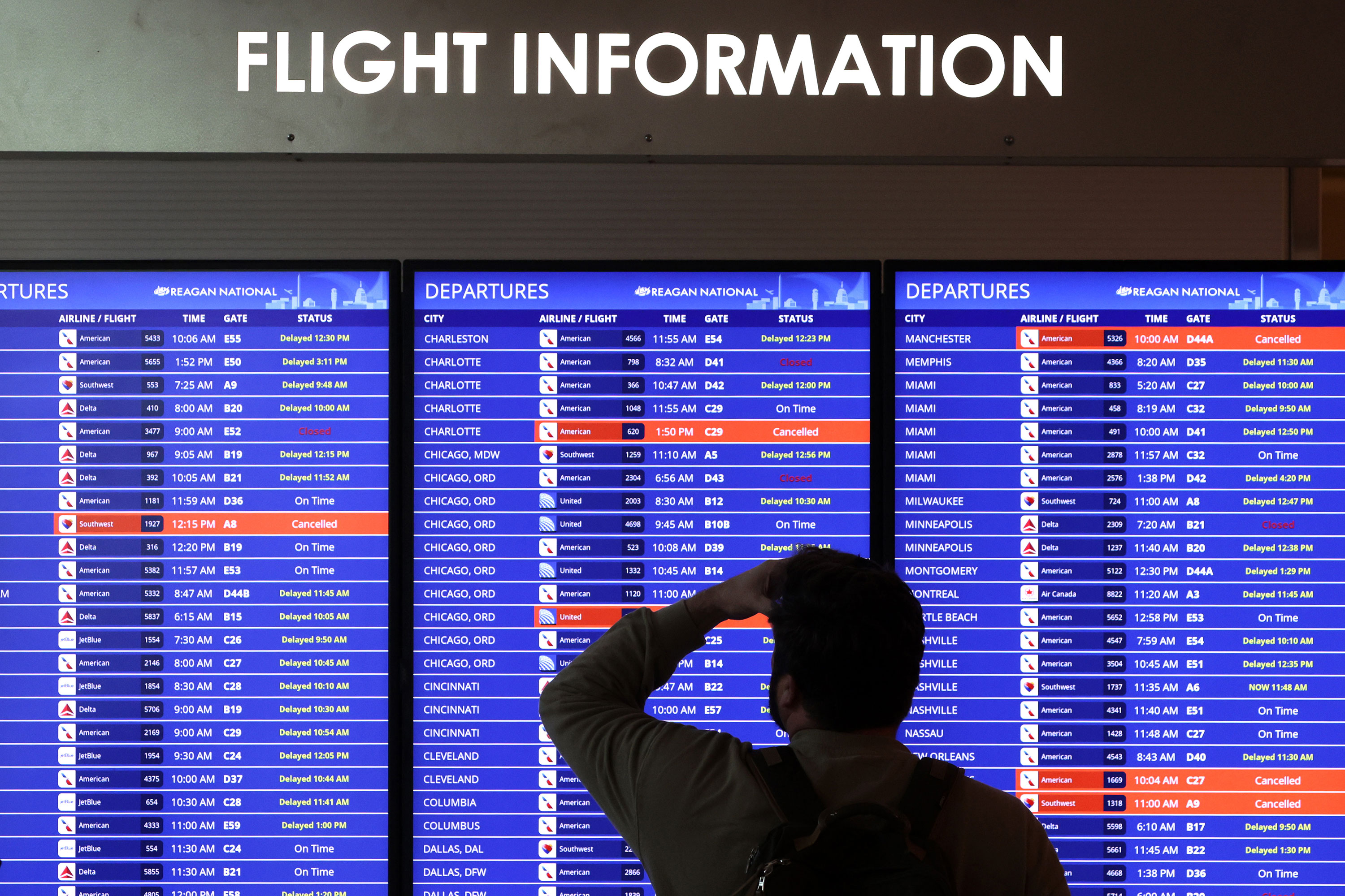 A traveler looks at a flight information board at Ronald Reagan Washington National Airport on Wednesday.