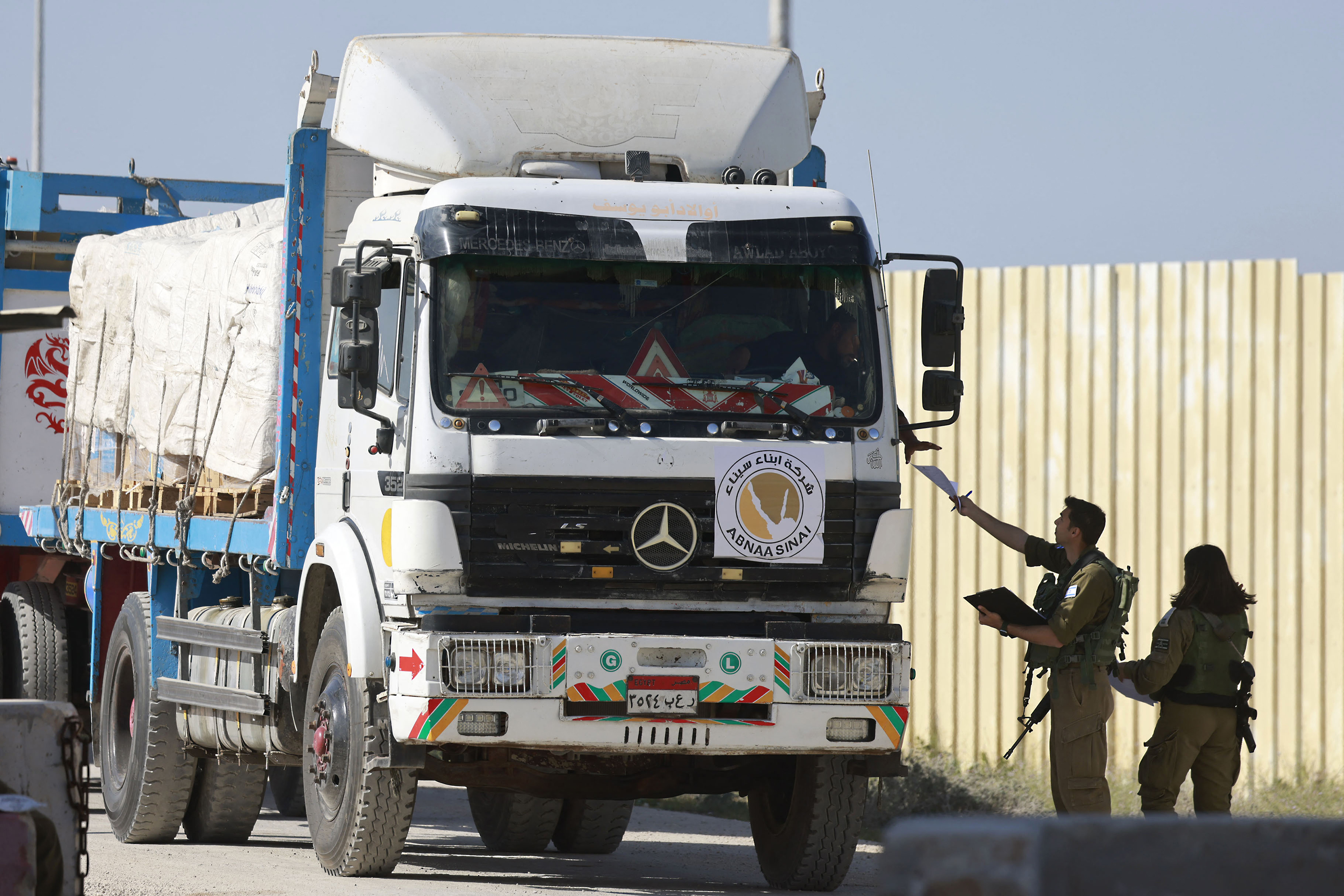 Israeli soldiers control an Egyptian truck carrying humanitarian aid at the Israeli side of the Kerem Shalom border crossing with the southern Gaza Strip on January 22.