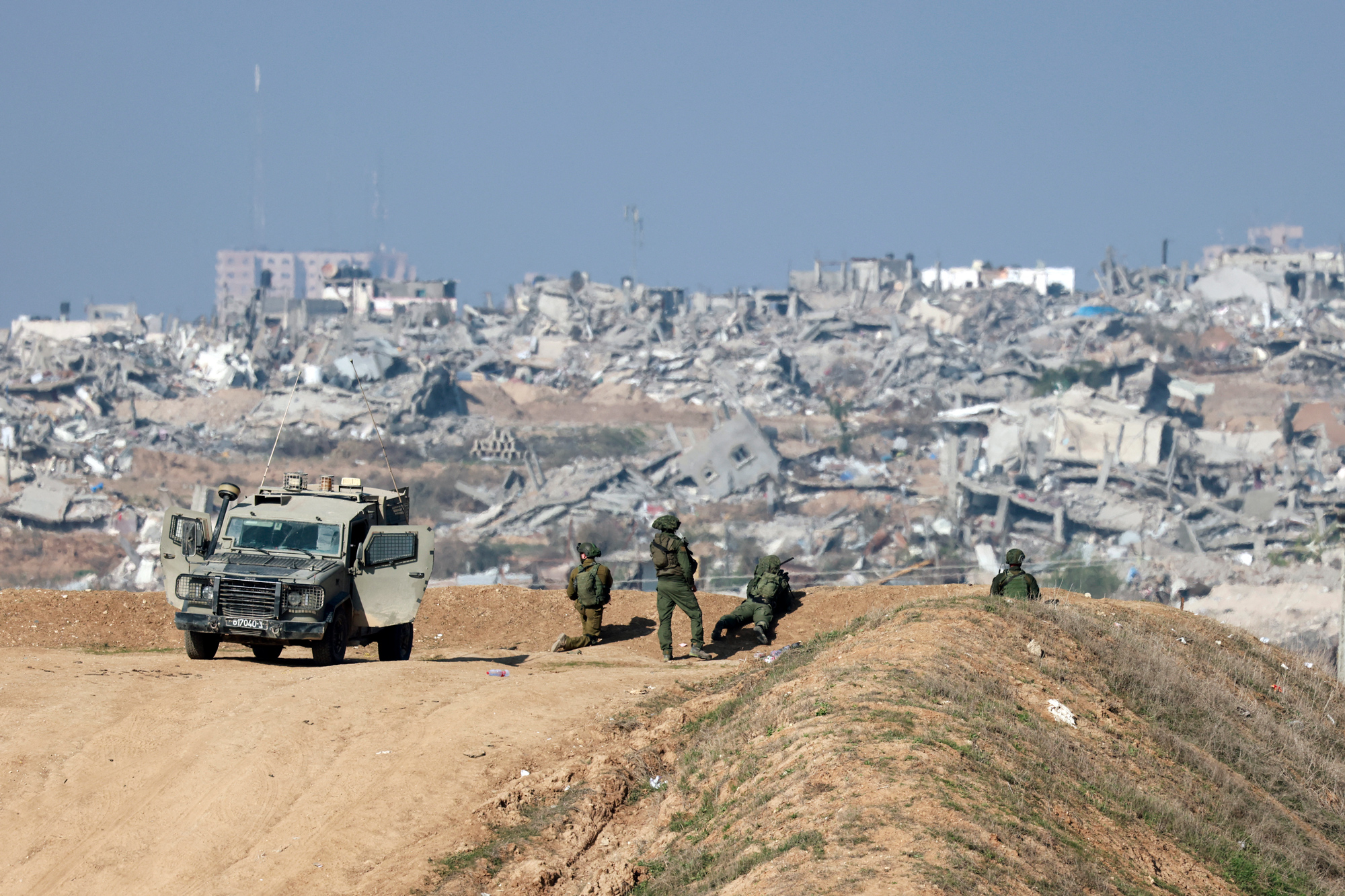Israeli soldiers watch Gaza City from a position on the Israeli border with northern Gaza on January 1.