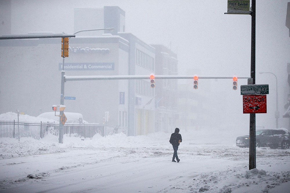 A person crosses a snow covered street on Friday, November 18, in Buffalo, New York.