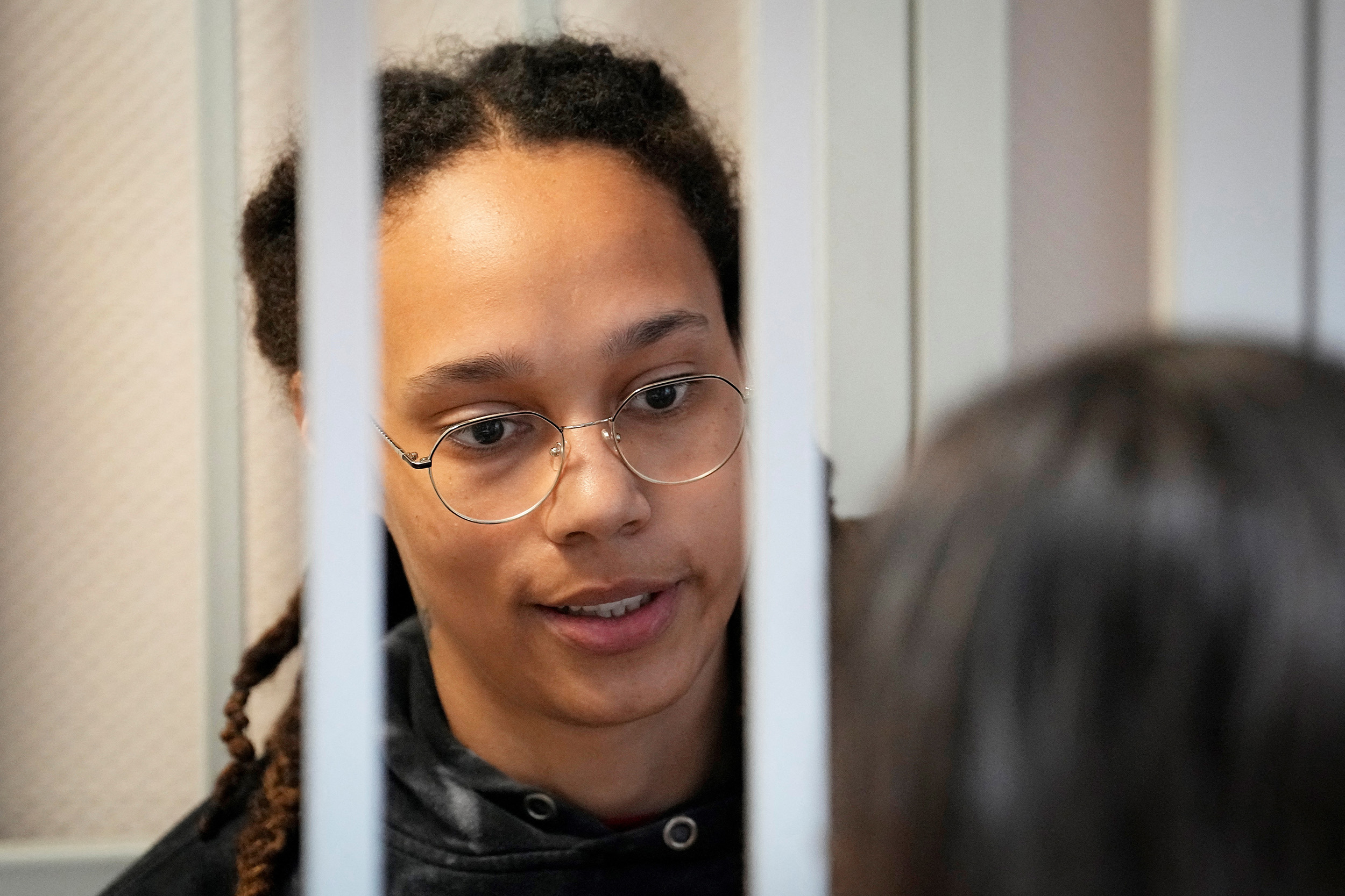 WNBA star and two-time Olympic gold medalist Brittney Griner speaks with her lawyers standing in a cage at a court room prior to a hearing, in Khimki just outside Moscow, Russia, on July 26.