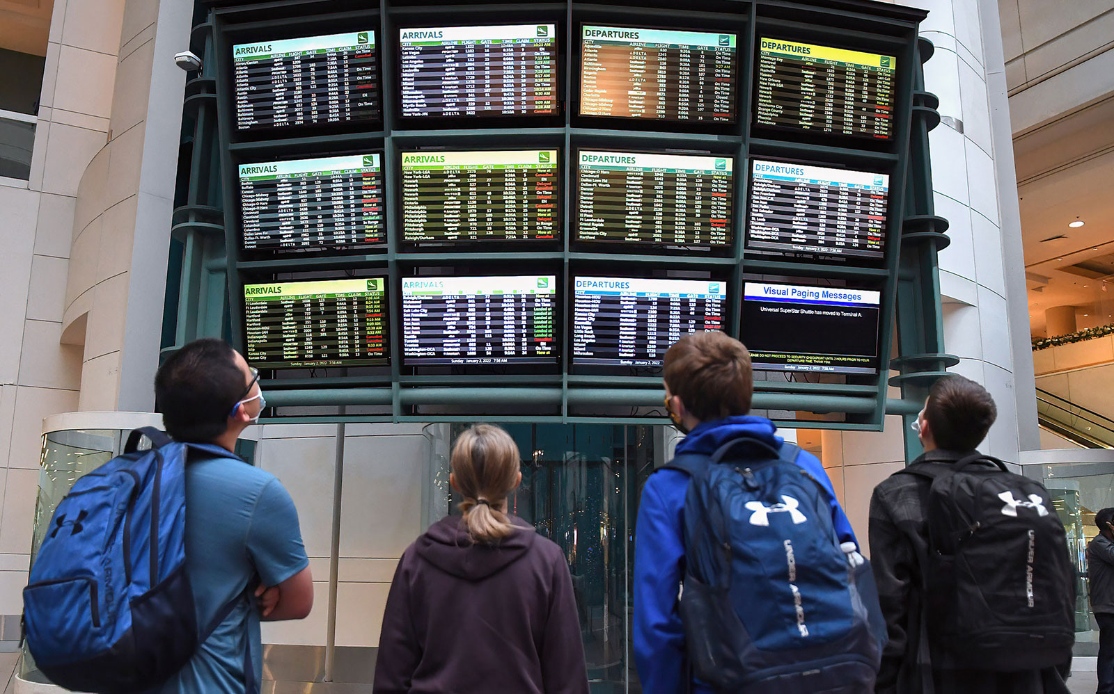 Travelers look at a board showing delayed and cancelled flights at Orlando International Airport on January 2. Nearly 18,000 flights have been cancelled since December 24.