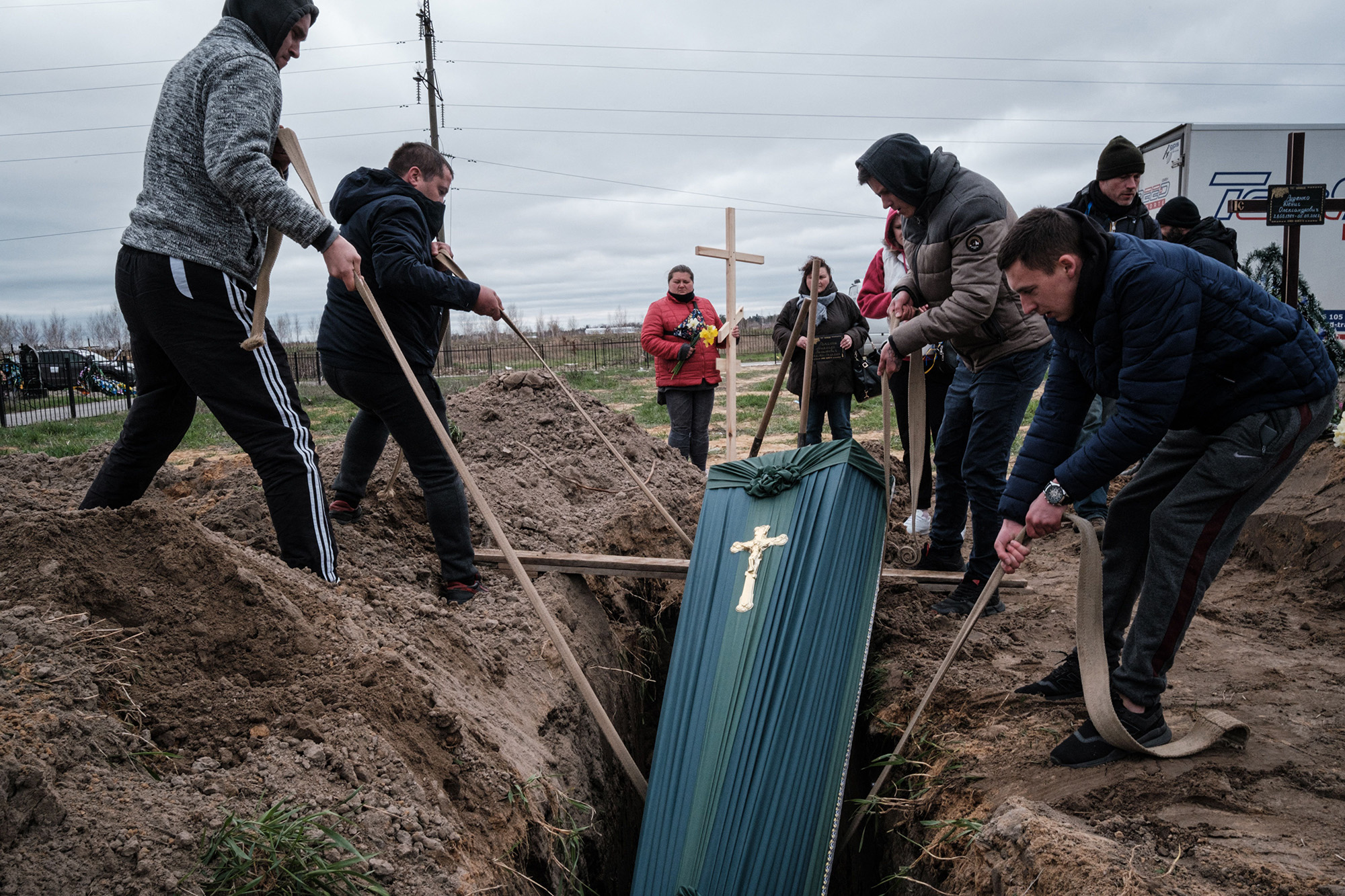 Relatives of Mykhailo Romaniuk, 58, who was shot dead on his bicycle on March 6, help to bury his coffin at a cemetery in Bucha, Ukraine, on April 19.