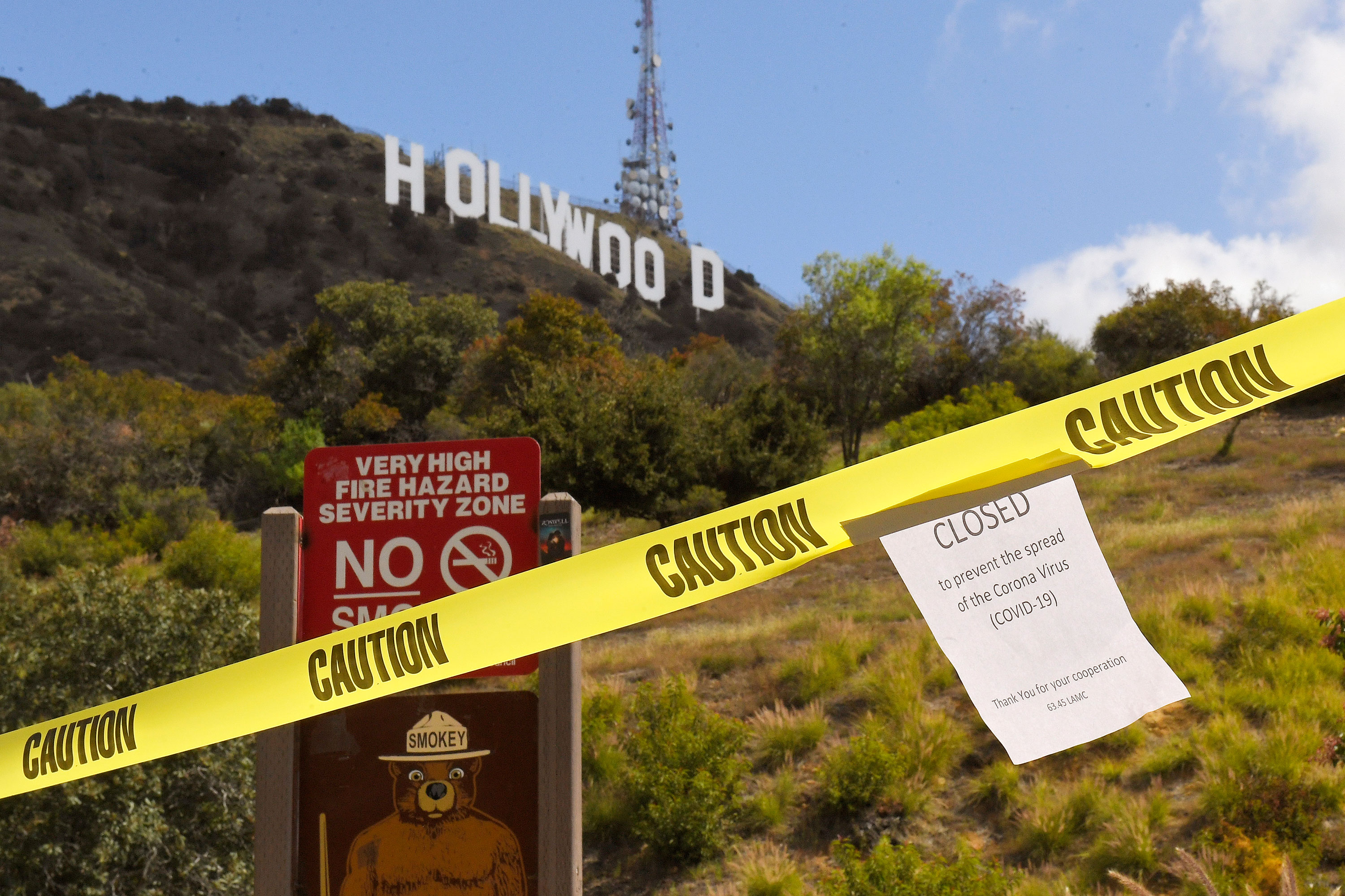 A sign about the closure of the Innsdale Trail is posted at the trail's entrance near the Hollywood sign in Los Angeles on March 28.