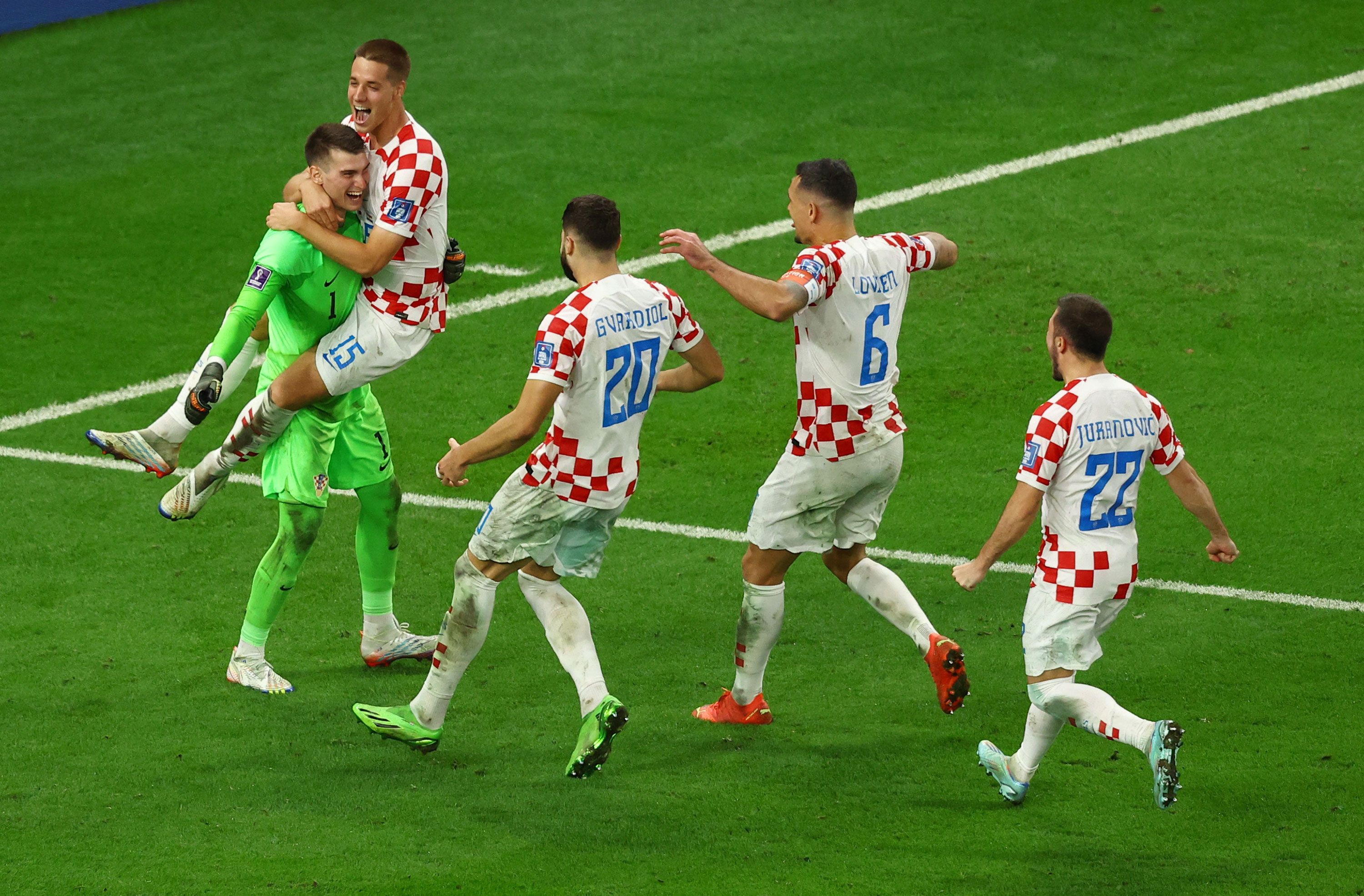 Croatia's goalkeeper Dominik Livakovic celebrates teammates after winning the penalty shootout against Japan.