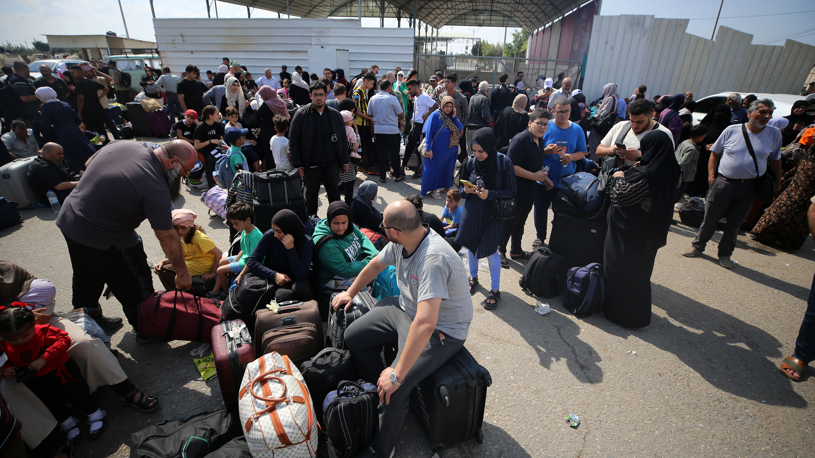 Palestinians, some with foreign passports hoping to cross into Egypt and others waiting for aid, wait at the Rafah crossing in the Gaza Strip on Monday.
