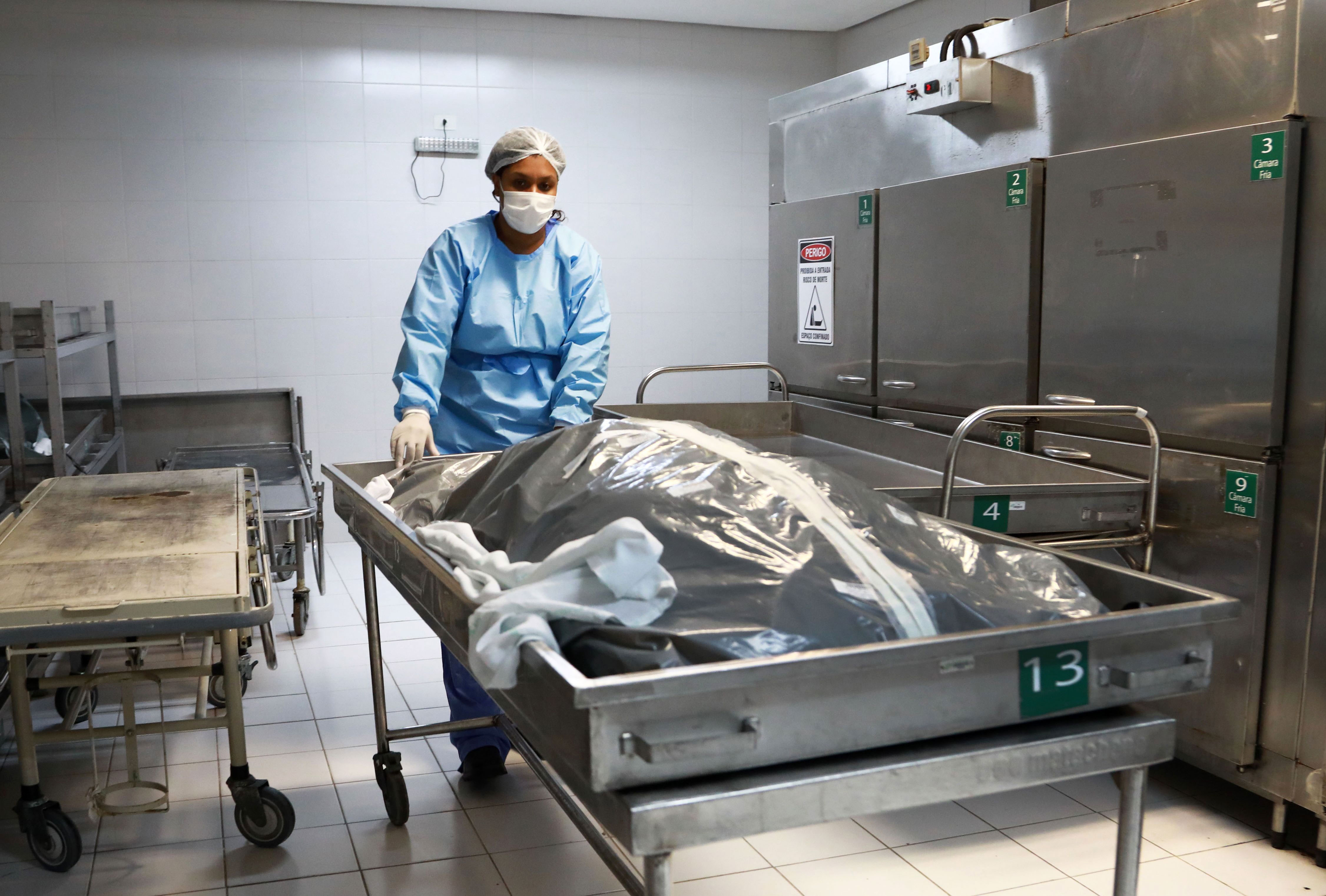 A morgue employee works with the body of a Covid-19 victim at a hospital in Porto Alegre, Brazil, on March 4.
