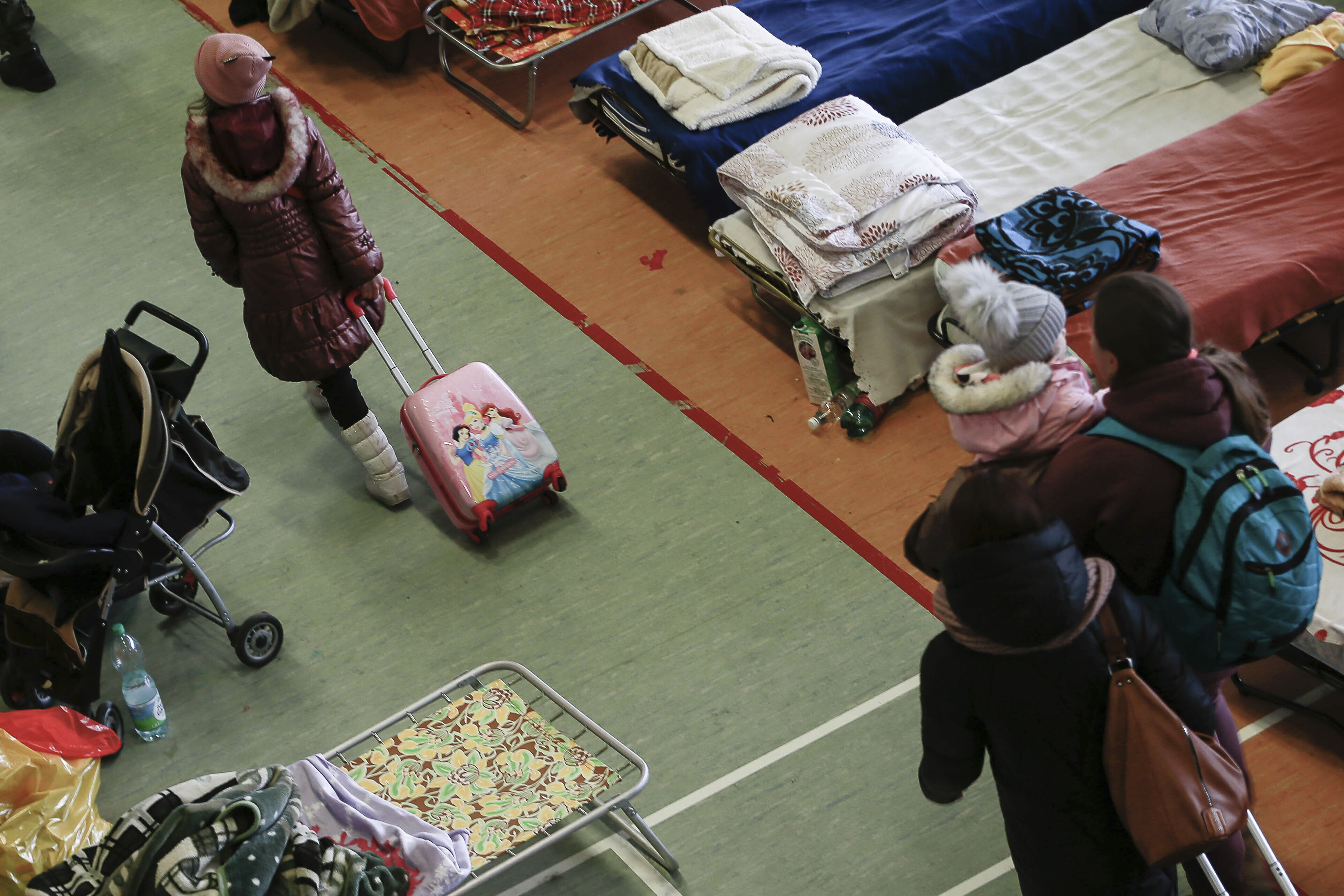A girl walks among hundreds of beds inside a sports hall used to accommodate Ukrainian refugees at the border crossing town of Medyka, Poland, on March 1.