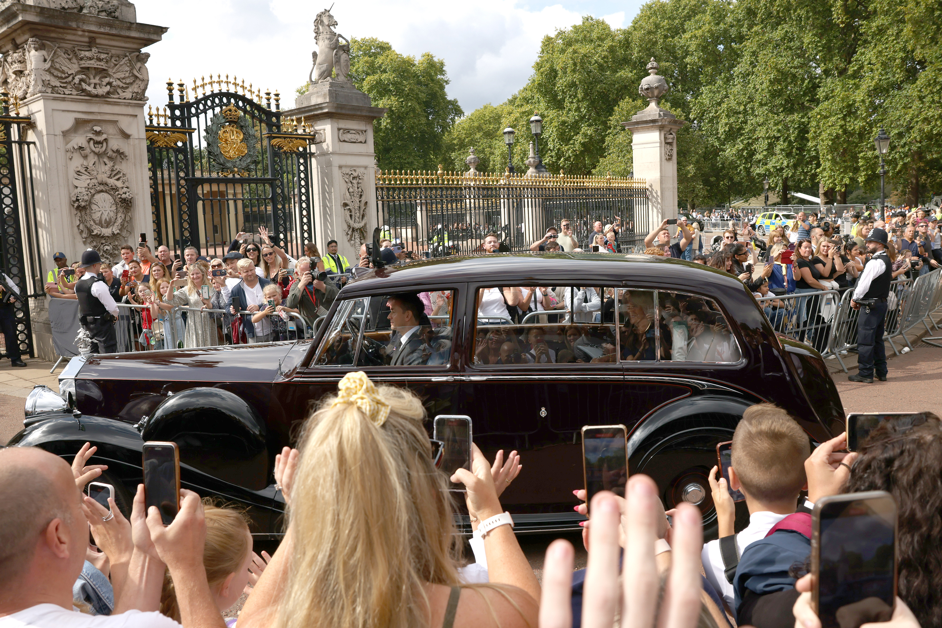 Members of the public gather to watch Britain's King Charles III arrive by car at Buckingham Palace in London on September 11.
