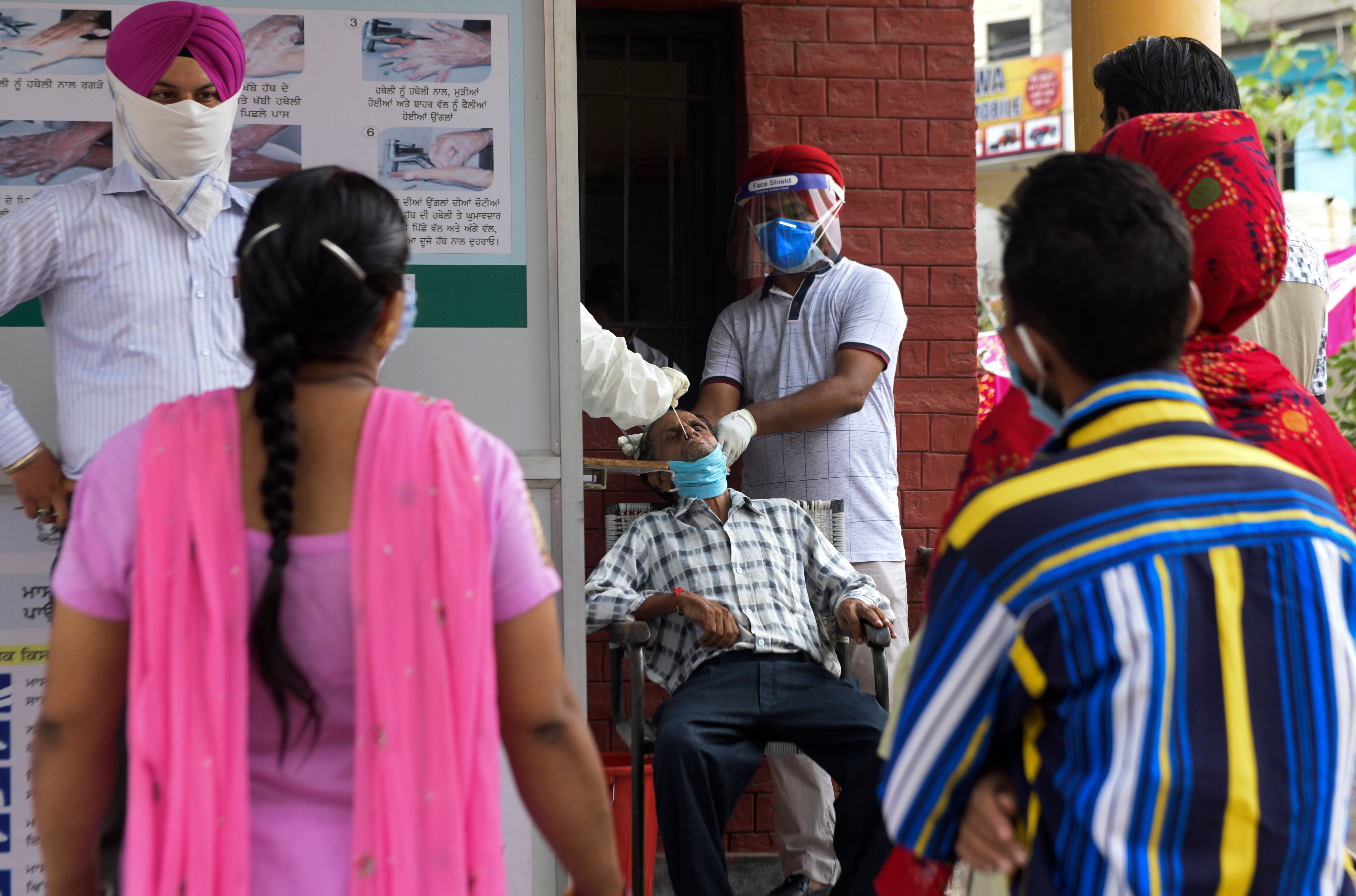 Health officials at a hospital in Amritsar, India, collect a nasal swab sample to test for Covid-19 on September 2.