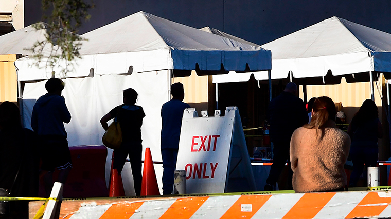 People wait in line to get a Covid-19 test at a testing center in Los Angeles, California on December 16, 2020.