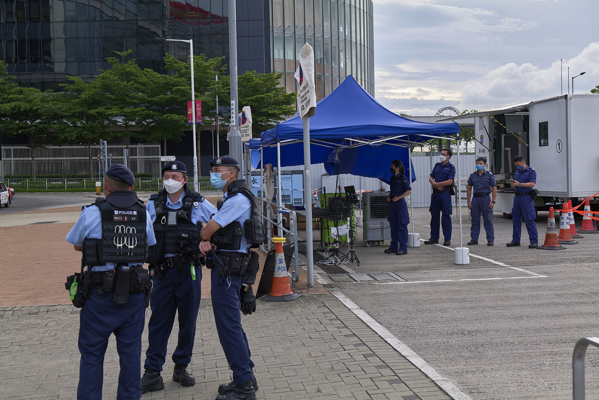 Police and mine clearance officers wait outside an X-ray baggage screening near the exhibition center in Hong Kong's Wan Chai district for the 25th anniversary on June 29. 